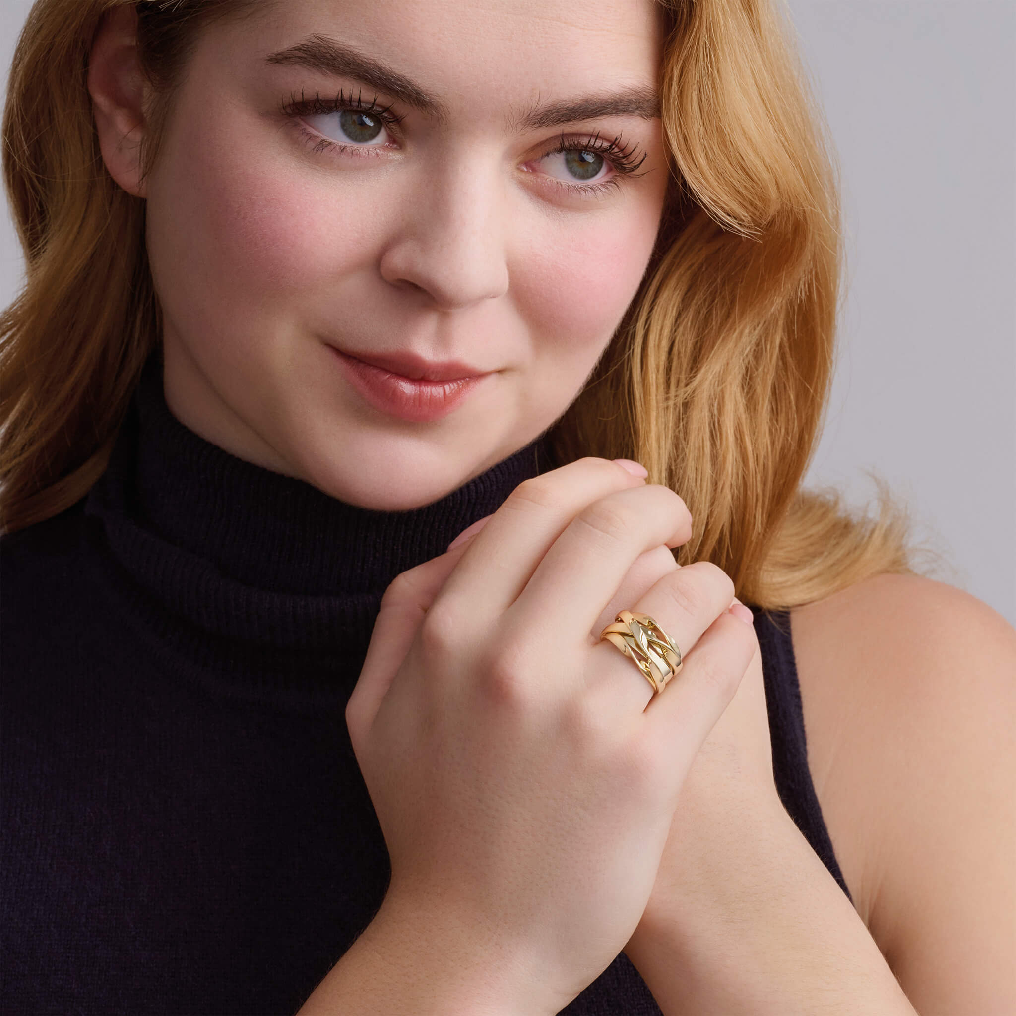 Model wearing a handcrafted yellow gold ring featuring a nest of tagliatelle.