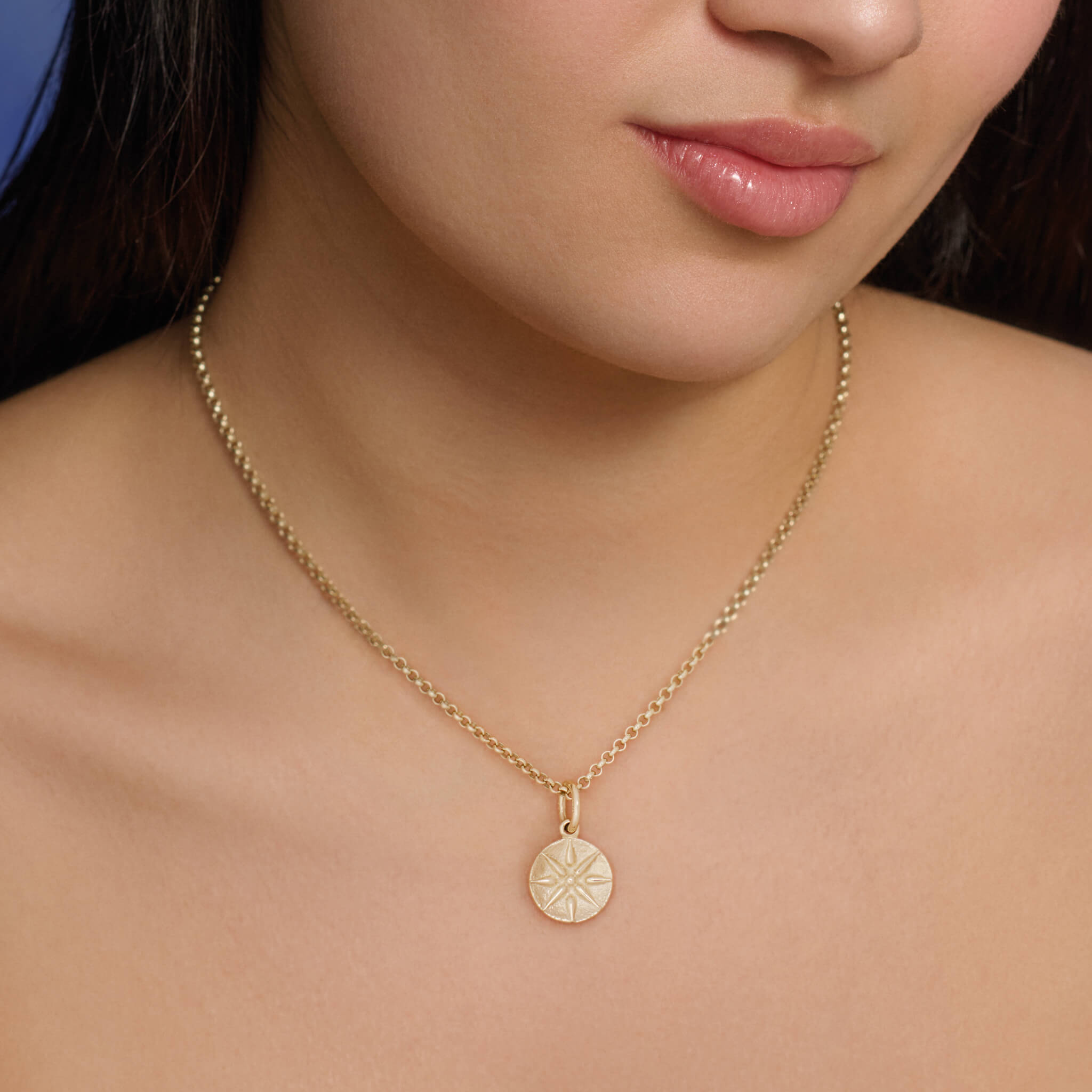 Model wears the handcrafted 9ct yellow gold necklace pendant with a star 'en relief'.