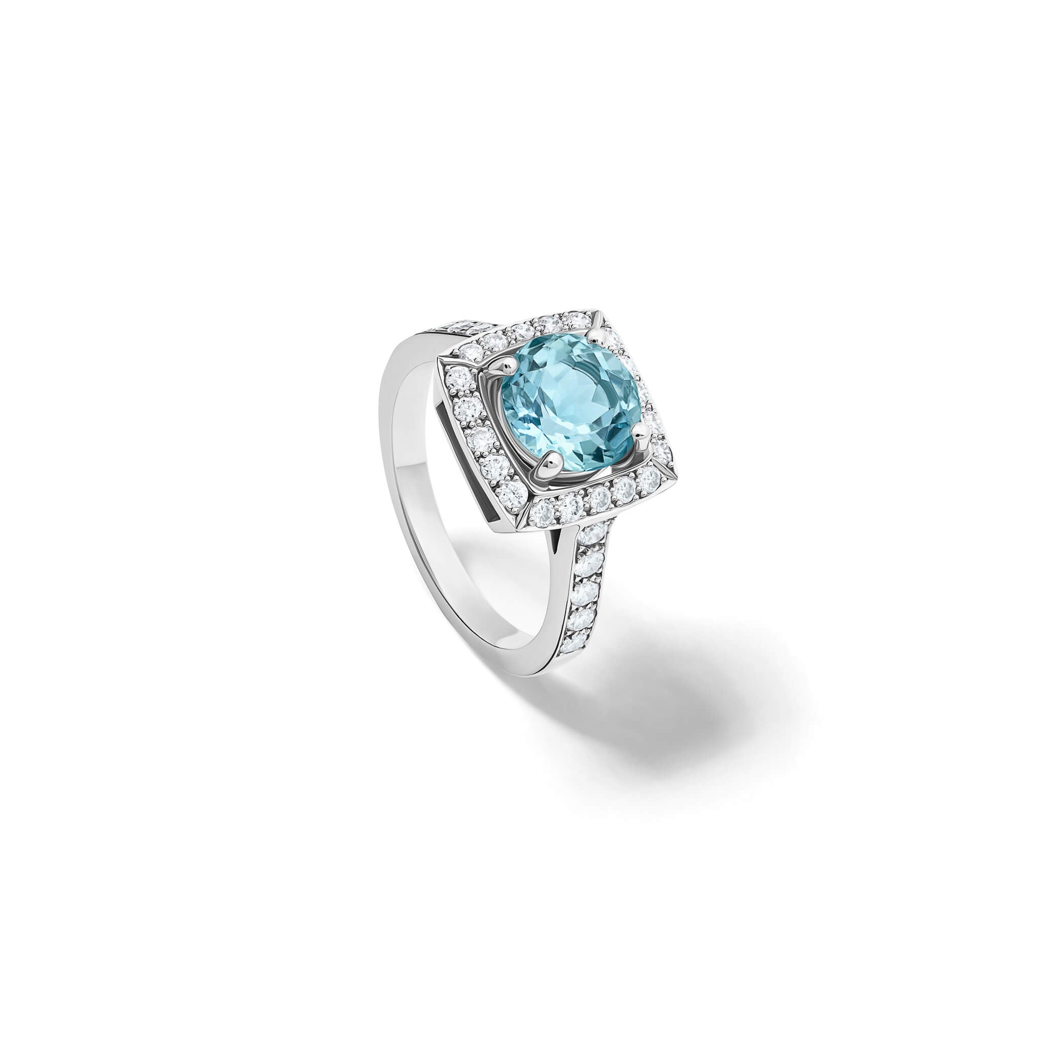 Handcrafted engagement ring in 18ct white gold with a central round cut aquamarine surrounded by a square halo of pavé diamonds with a pavé diamond shank.