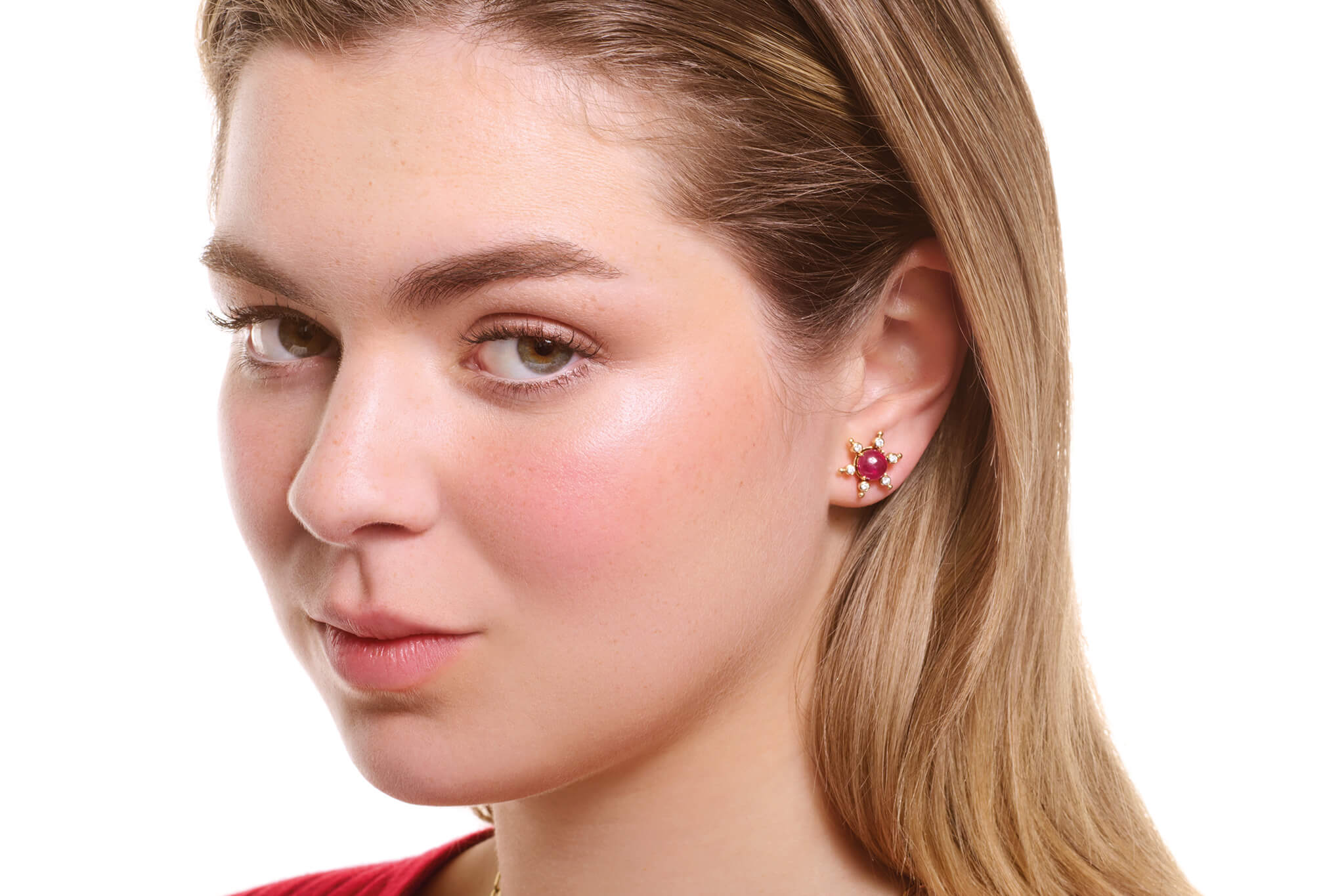 Model wearing cabochon ruby studs with halo.