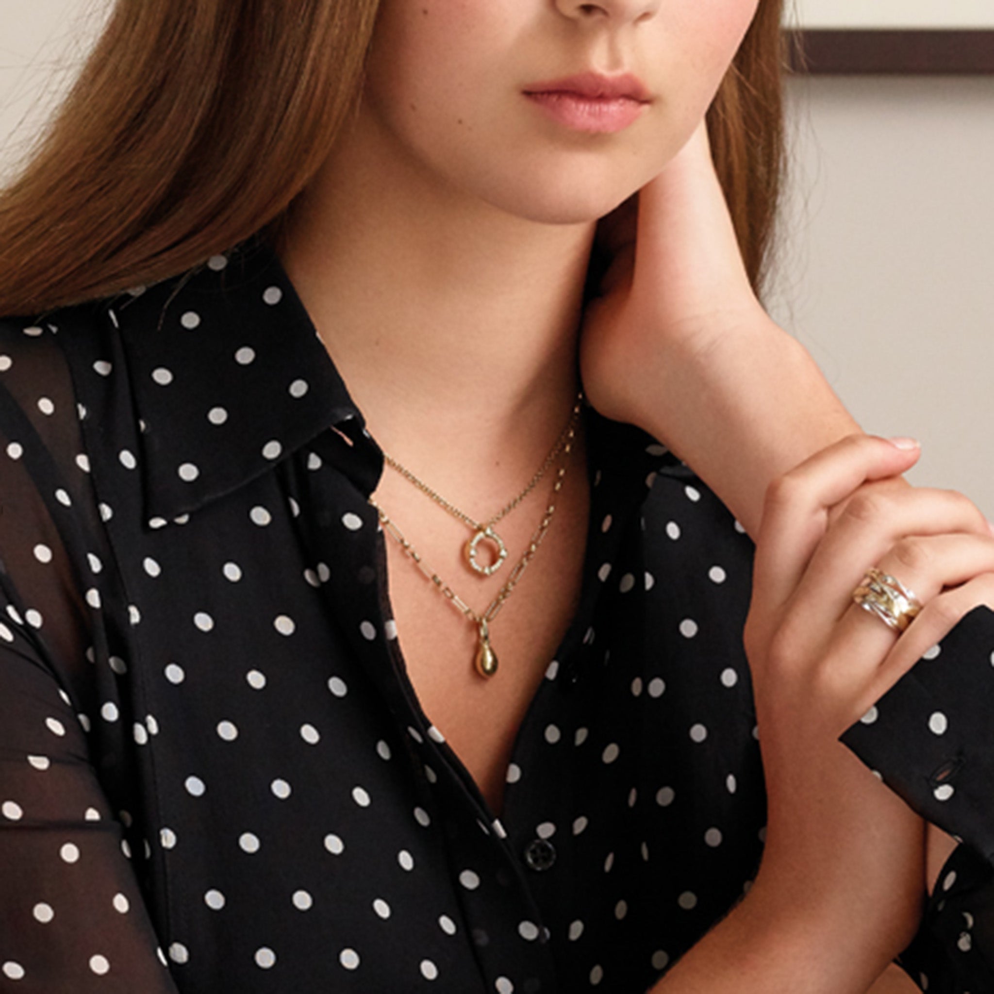 Model wearing a handcrafted yellow gold necklace pendant showcasing a cowrie shell.