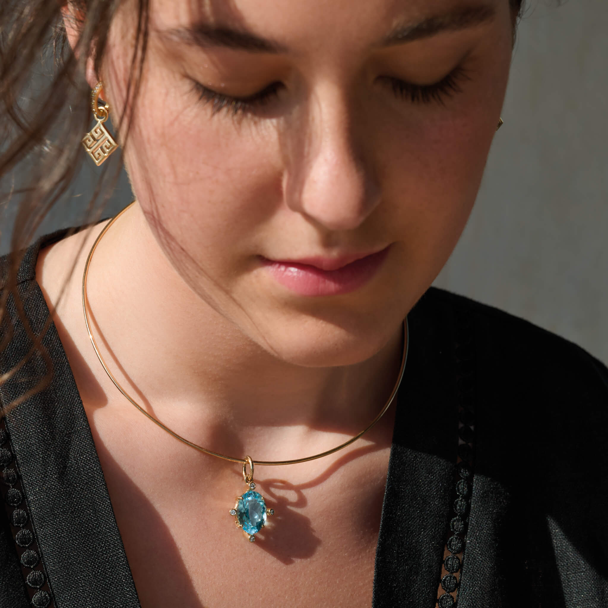 Model wears handcrafted 9ct yellow gold torque necklace inspired by the nymph Calypso.