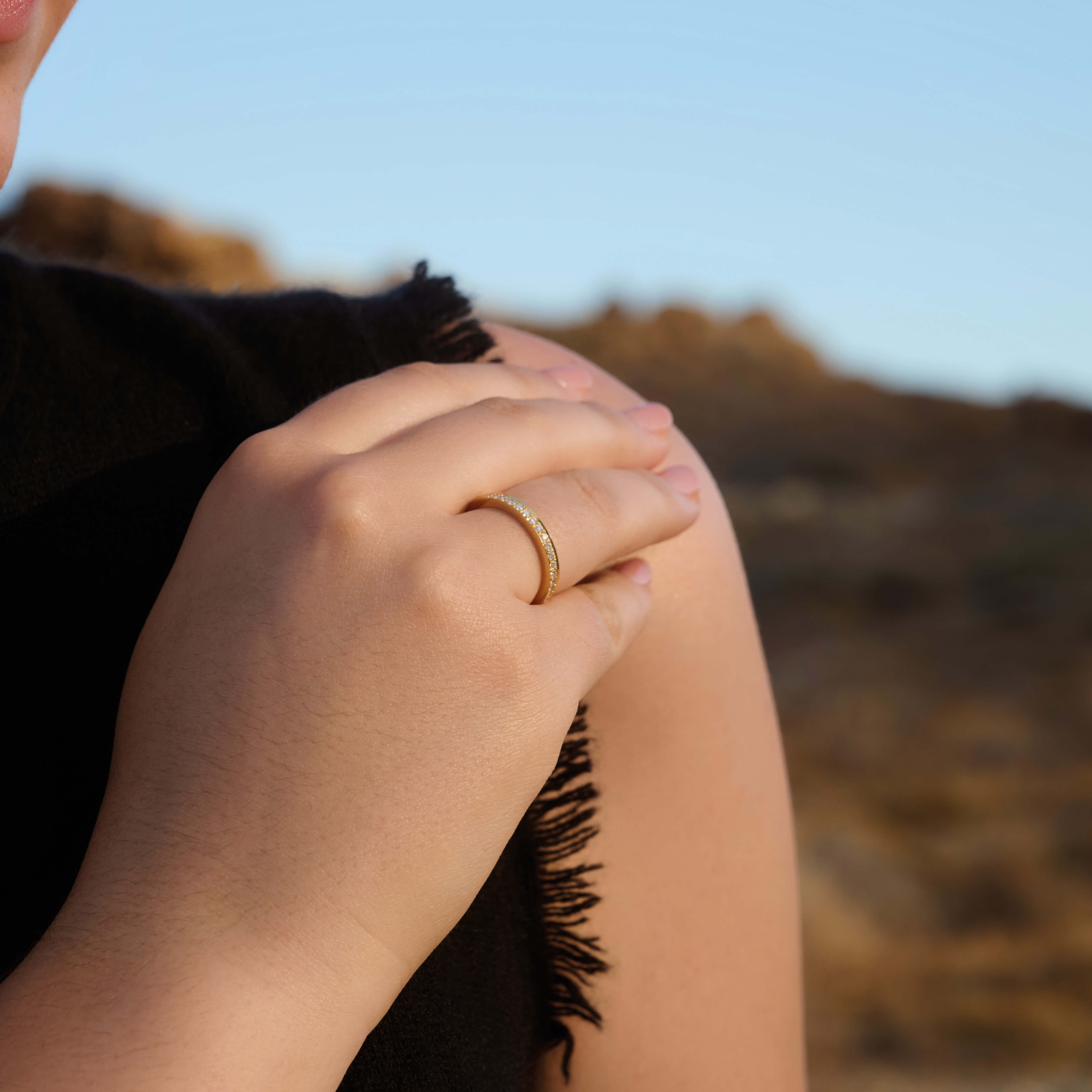 Model wearing a handcrafted 18ct gold eternity band with diamonds set along the band.