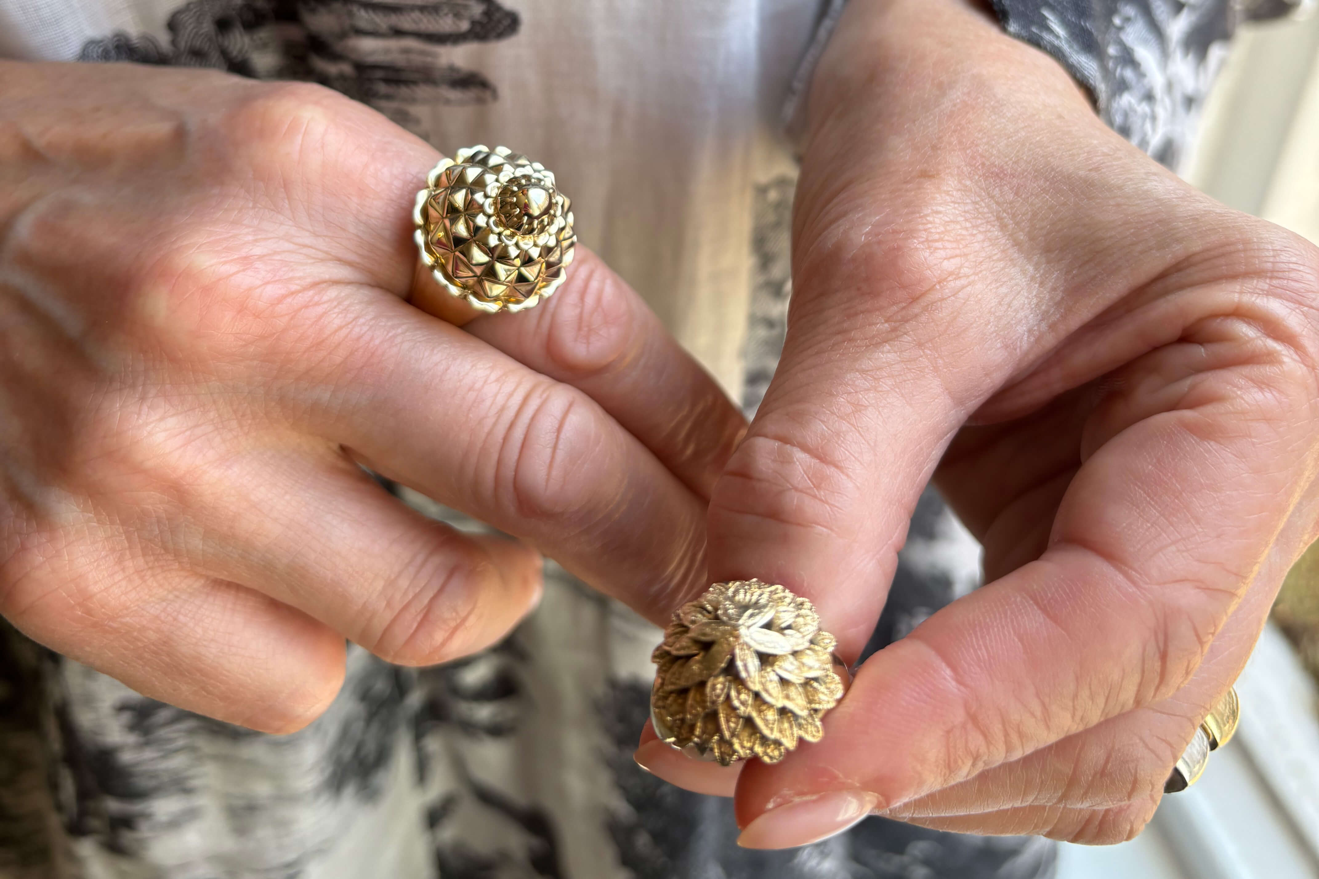 Cassandra holds two pineapple inspired 9ct yellow gold rings