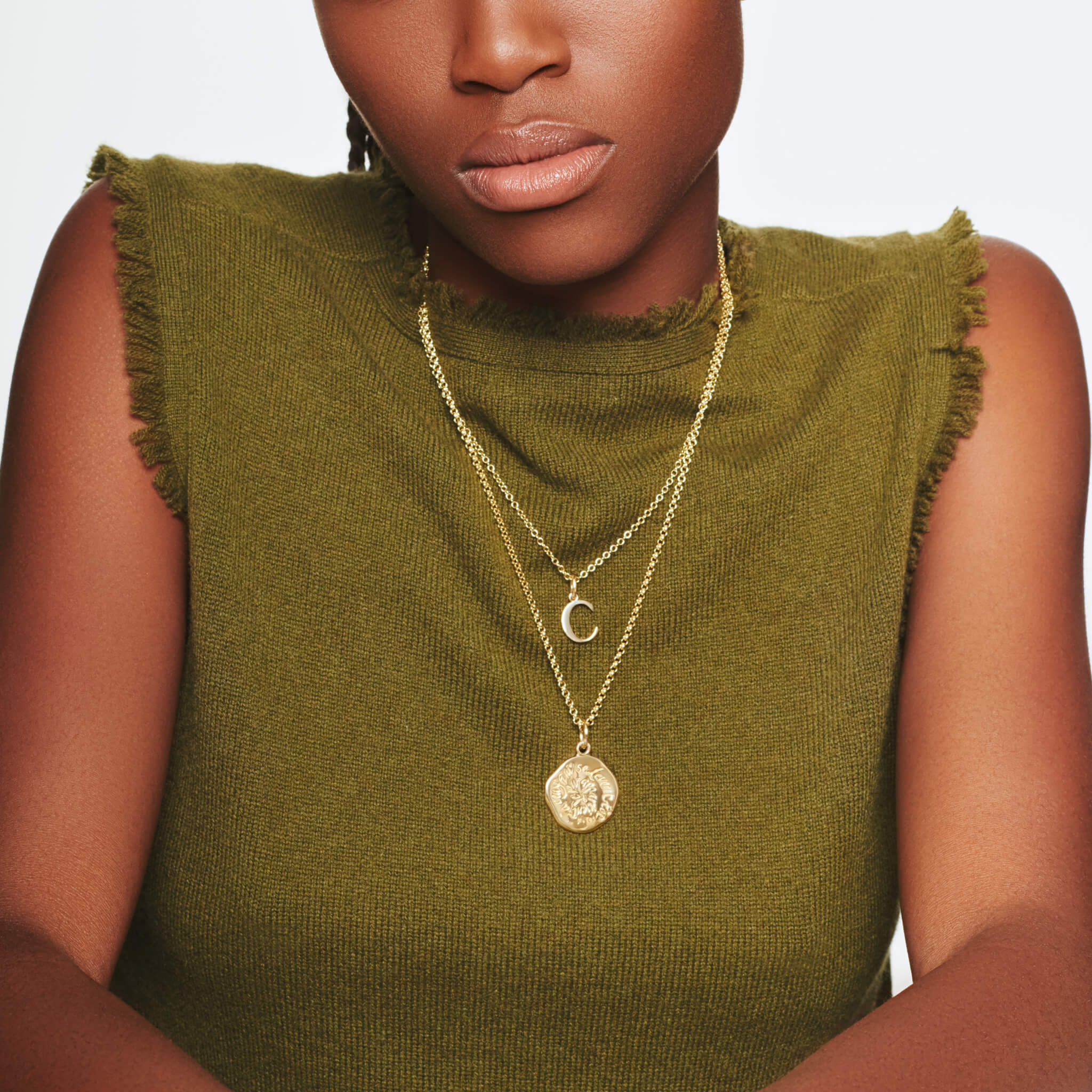 Model wearing handcrafted yellow gold initial C necklace pendant, with a loop at the top for chain attachment.