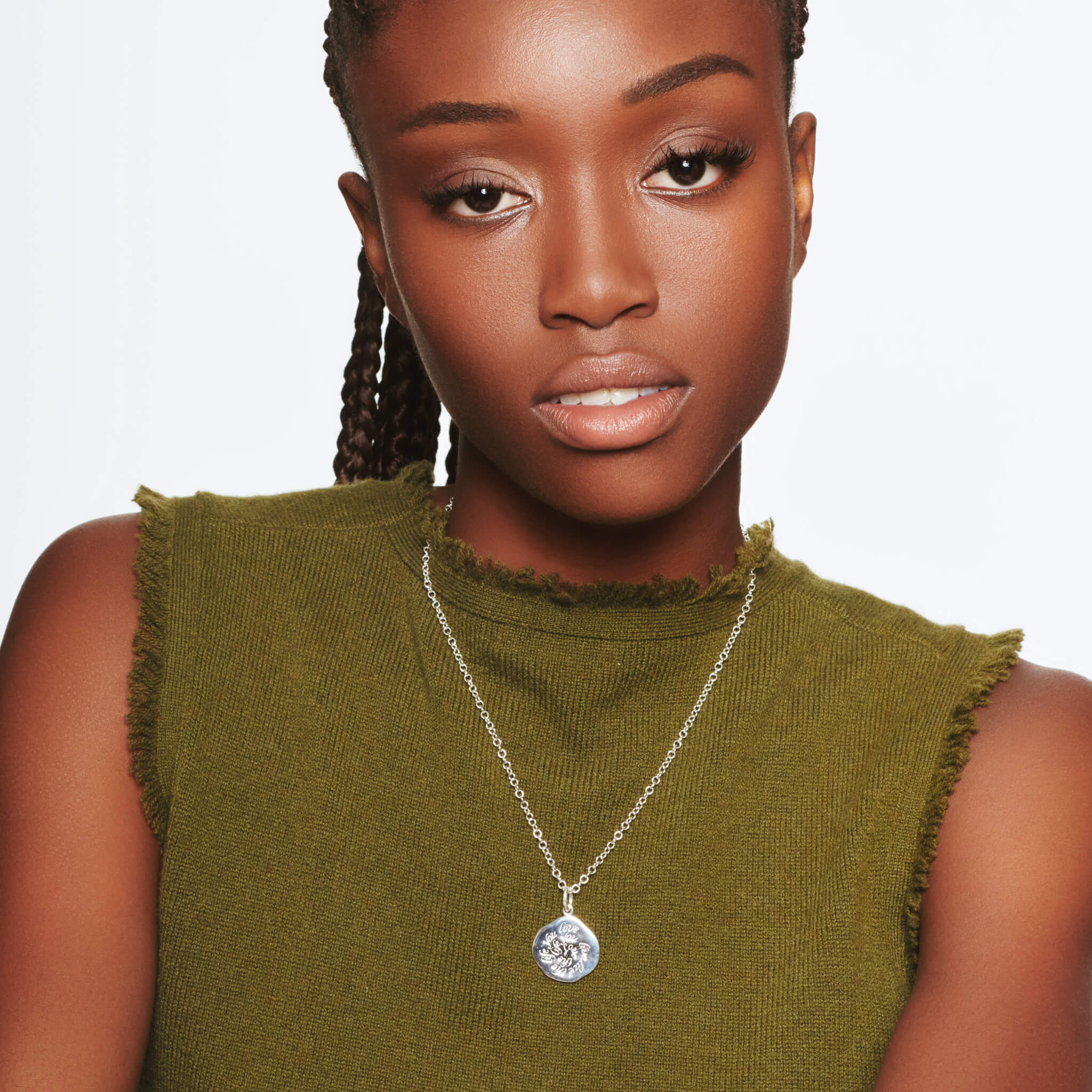 Model wearing handcrafted round silver necklace pendant engraved with a quote of wisdom