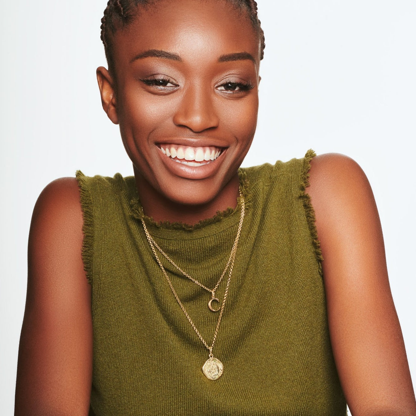 Model wearing a handcrafted round yellow gold pendant necklace engraved with the quote, 'Always remember the sense of wonder in the everyday.'
