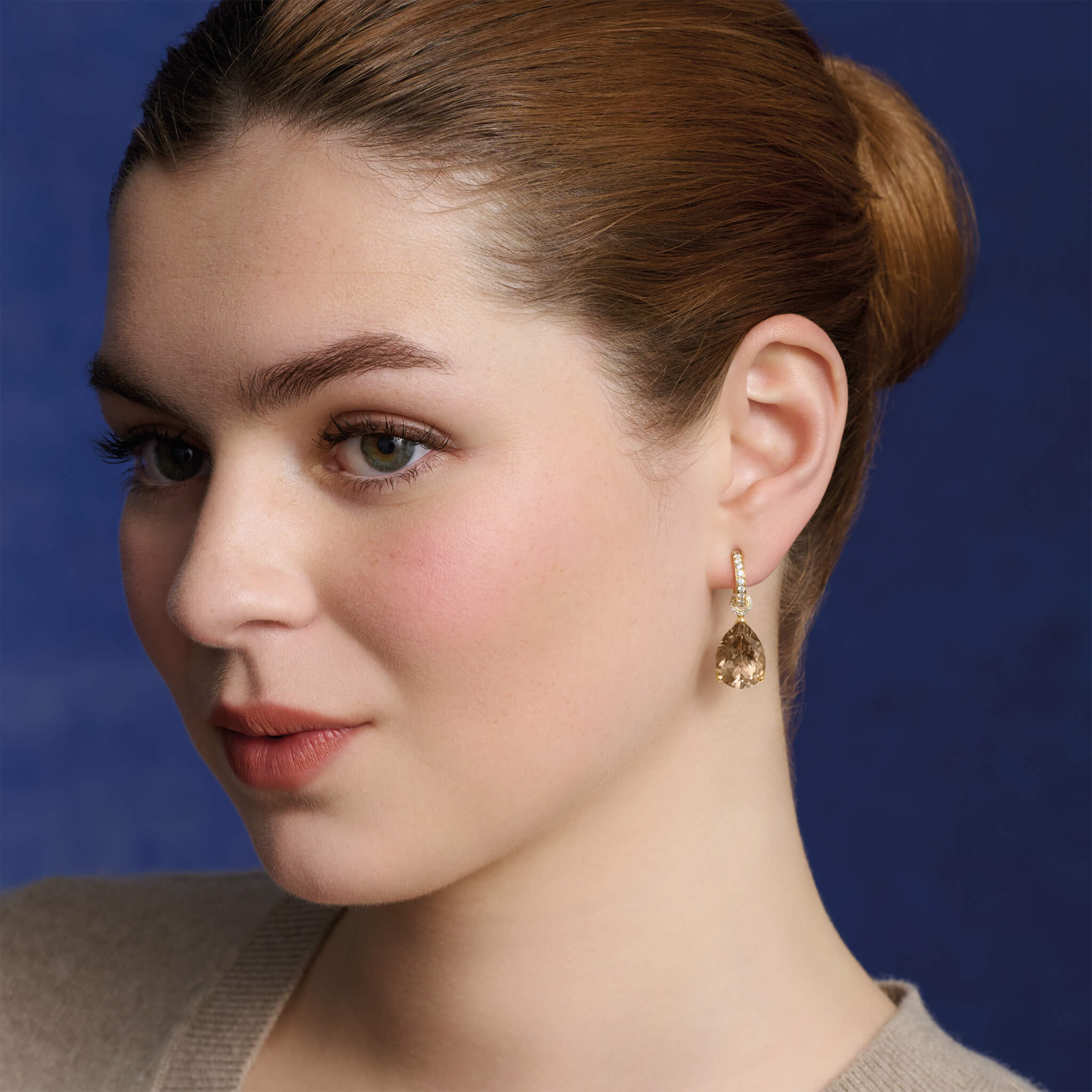 Model wears handcrafted yellow gold earring drops with teardrop shaped smoky quartz