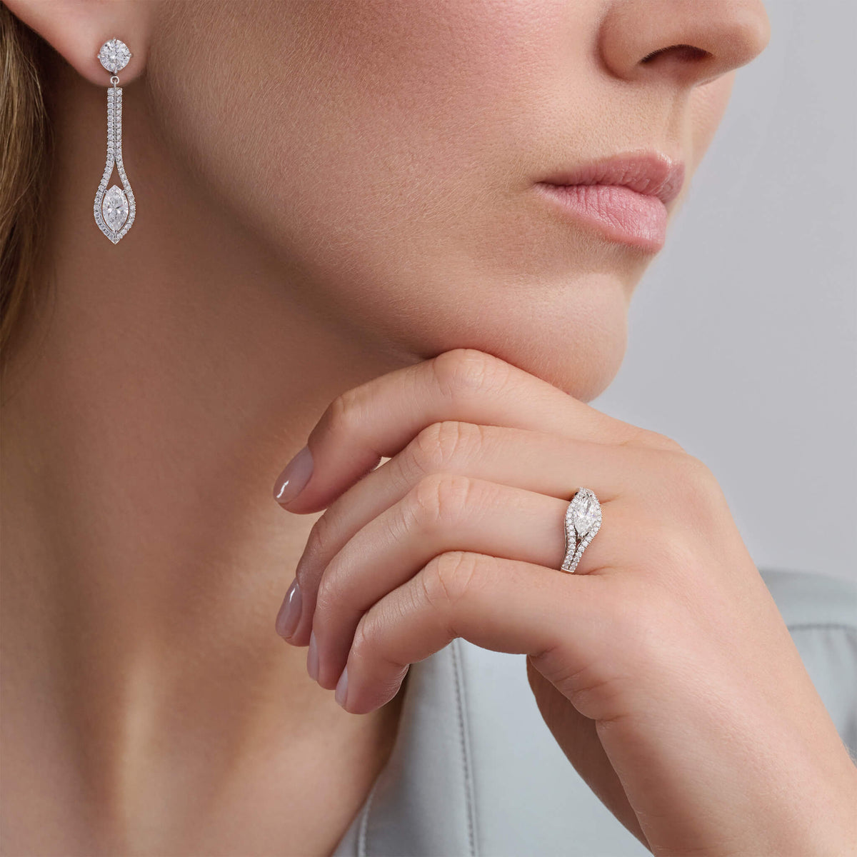 Model wearing handcrafted Marielle engagement ring in platinum with a central certified marquise cut diamond and diamond pave