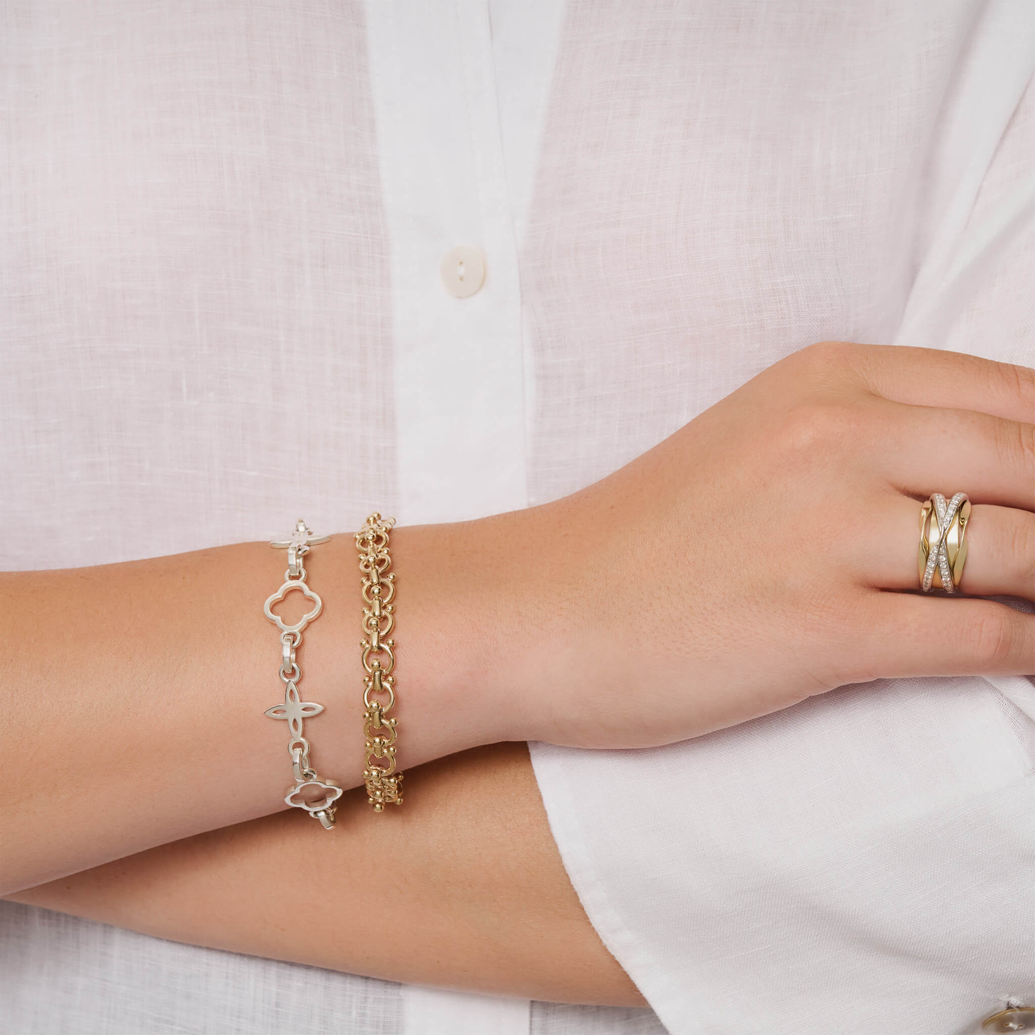Model wearing handcrafted silver bracelet with star-shaped links.