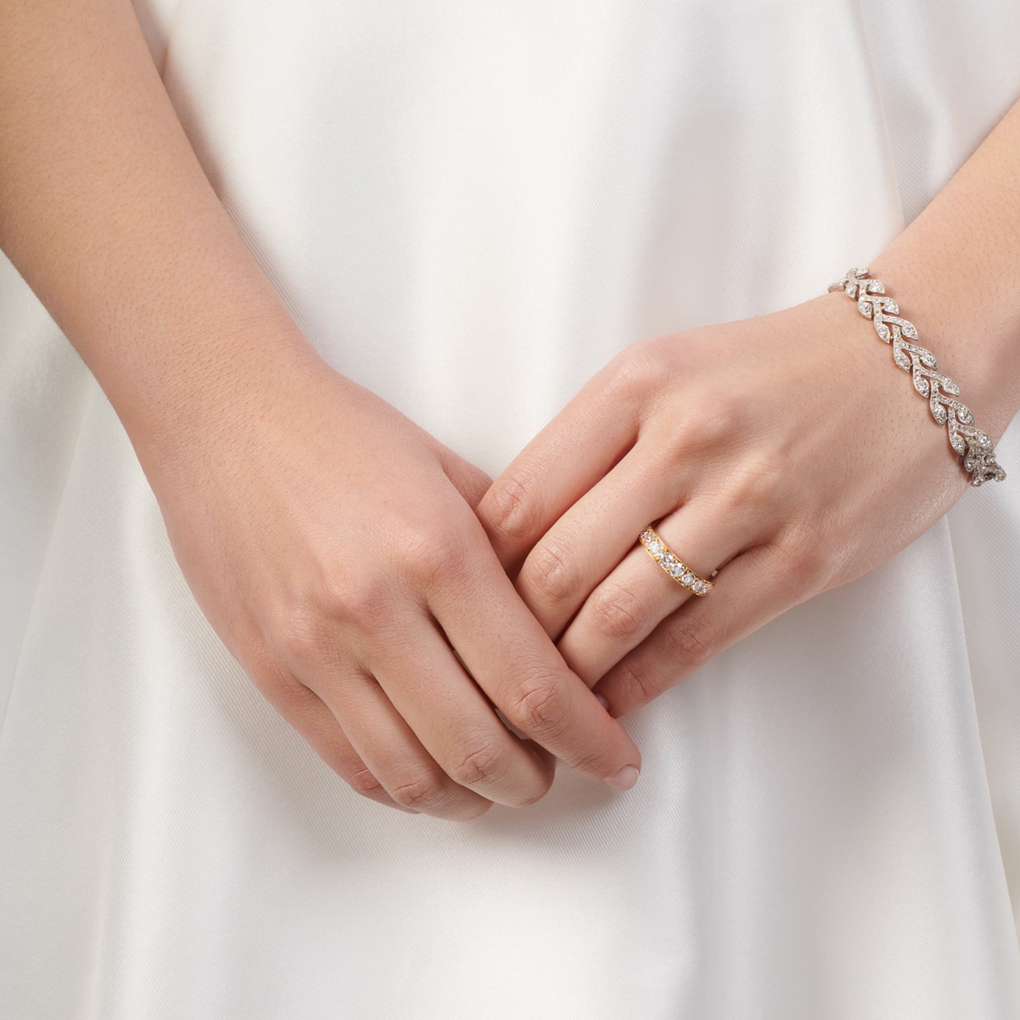 Model wearing a handcrafted 18ct yellow gold wedding band set with diamond along half of the band.