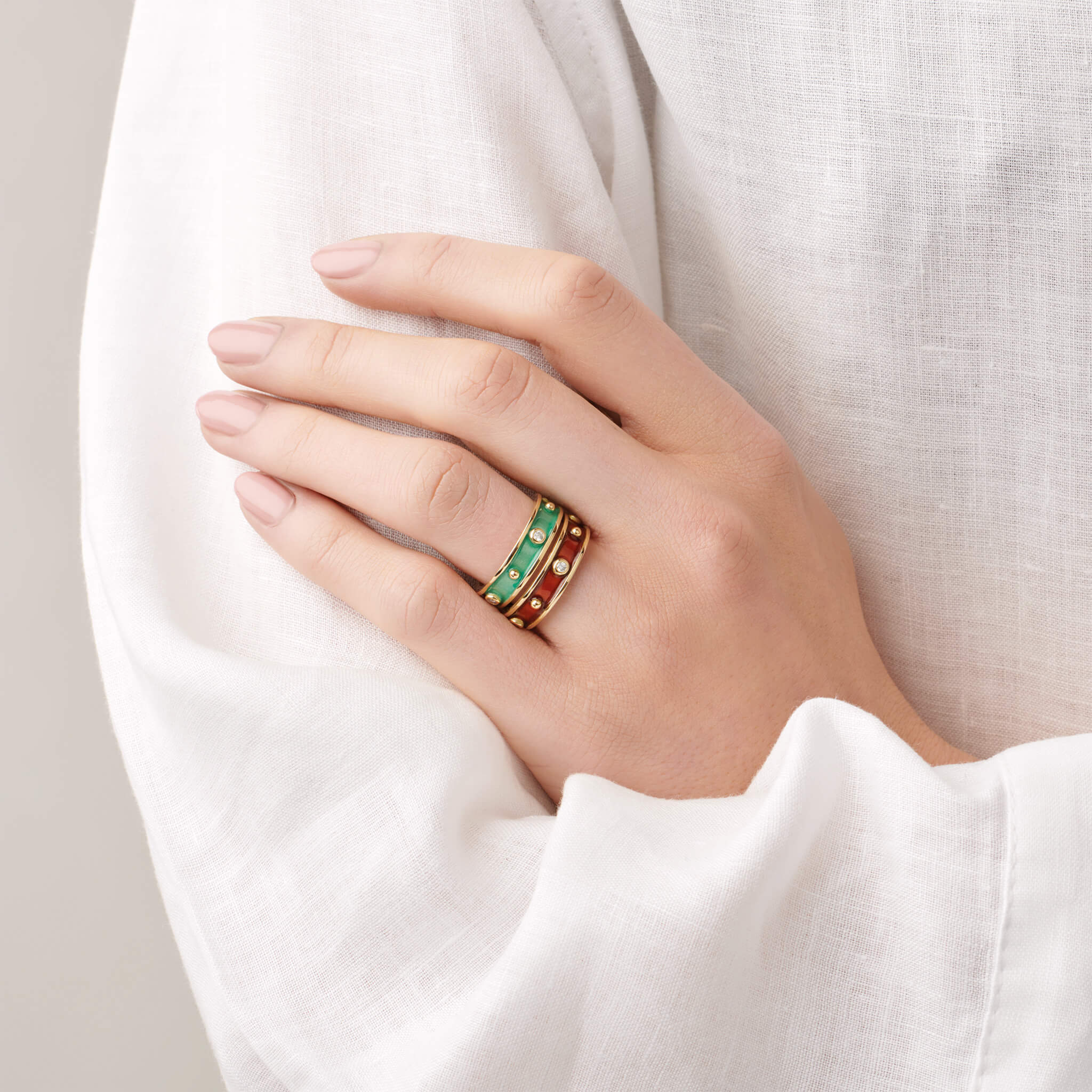 Model wears handcrafted yellow gold ring with evenly spaced, protruding round dots with turquoise enamel and diamond