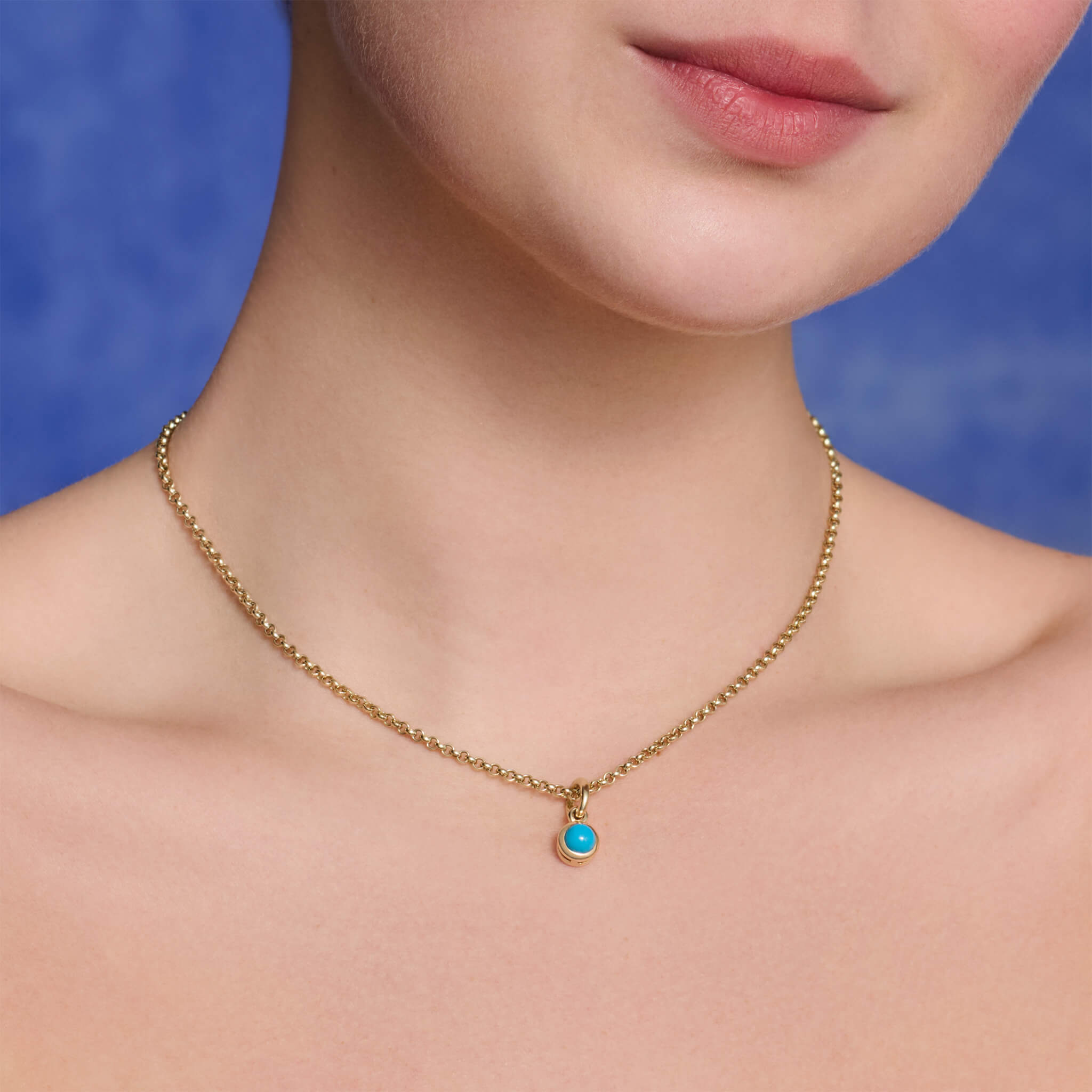 Model wears handcrafted necklace pendant in silver featuring featuring turquoise, December birthstone