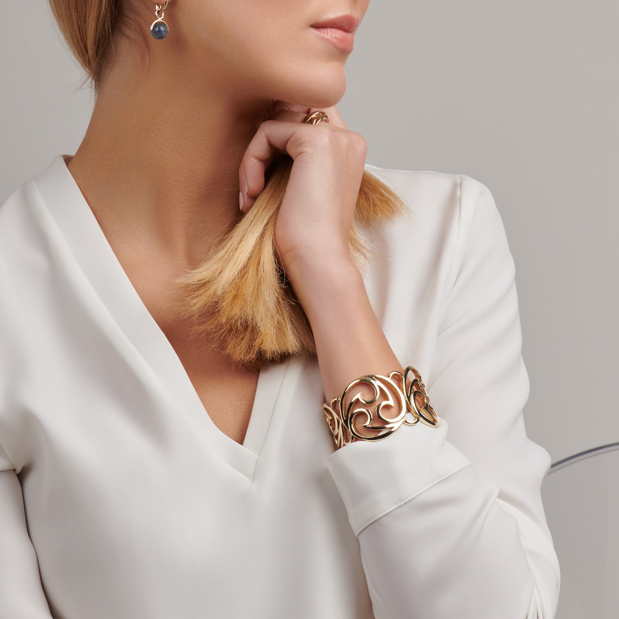 Model wearing a handcrafted yellow gold cuff bracelet featuring a Japanese whorl pattern.
