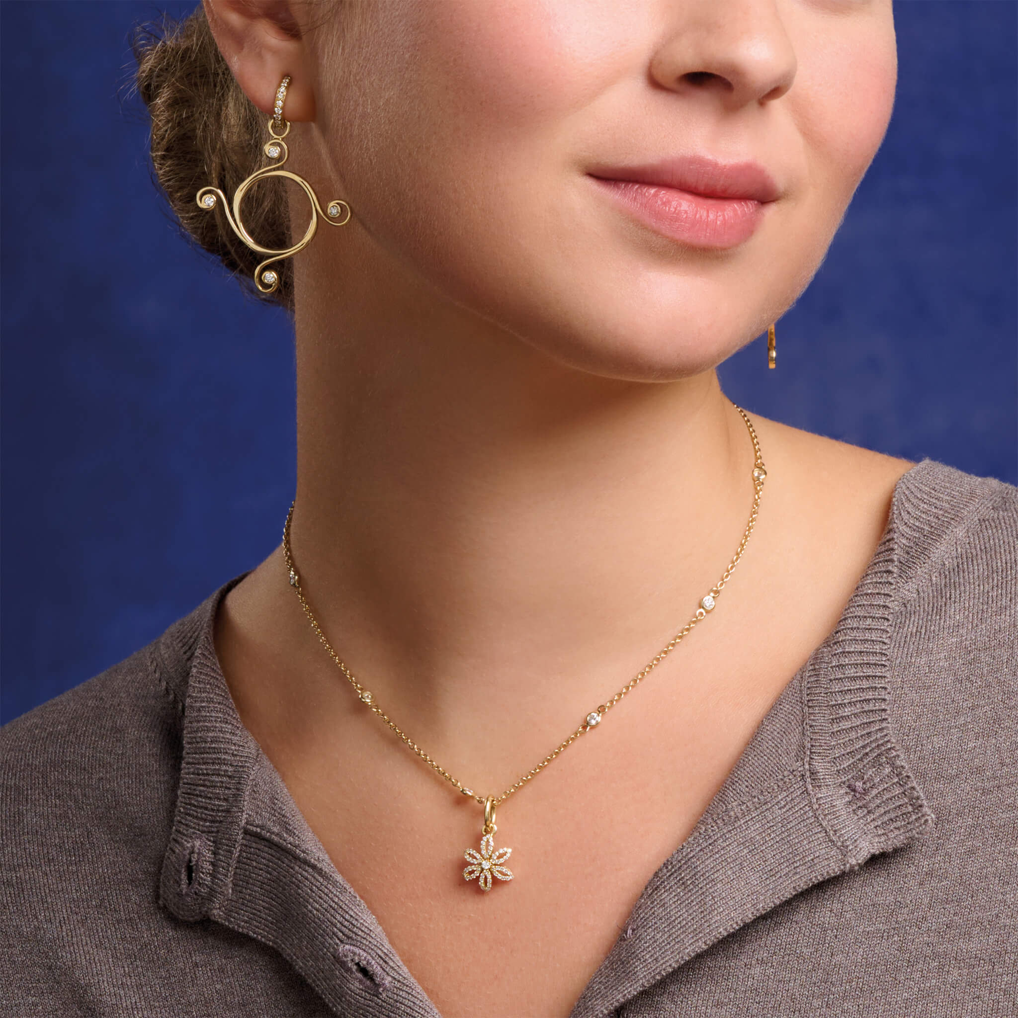 Model wearing handcrafted 18ct white gold flower necklace pendant with diamond pave and central diamond, birthstone of April.