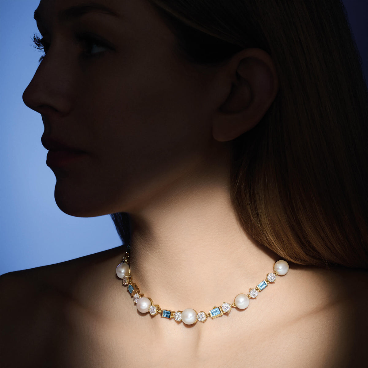 Model wearing handcrafted high jewellery Firework necklace in yellow gold with pearl, diamond and aquamarine