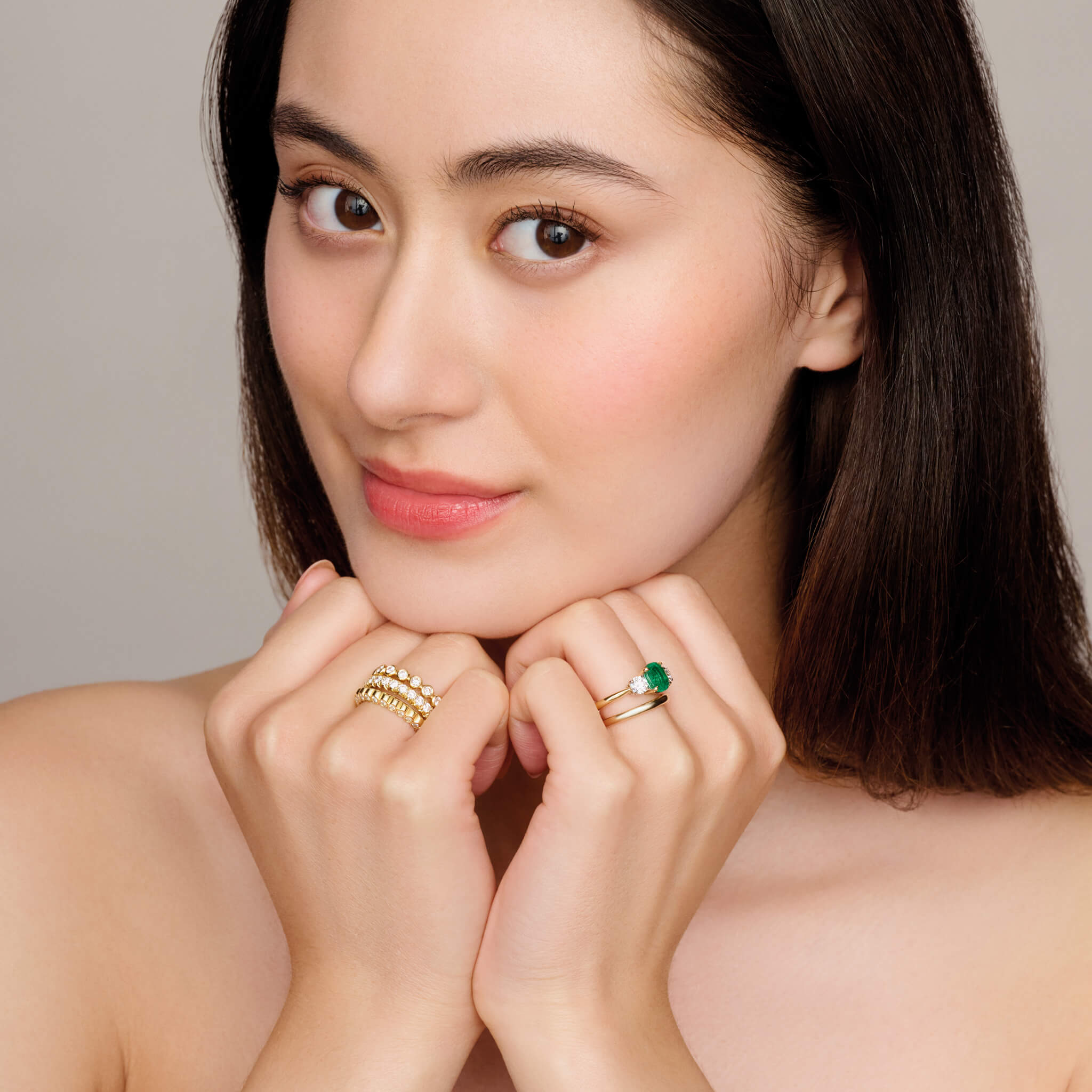 model wearing handcrafted full eternity ring in 18ct yellow gold with rub over set round diamonds.