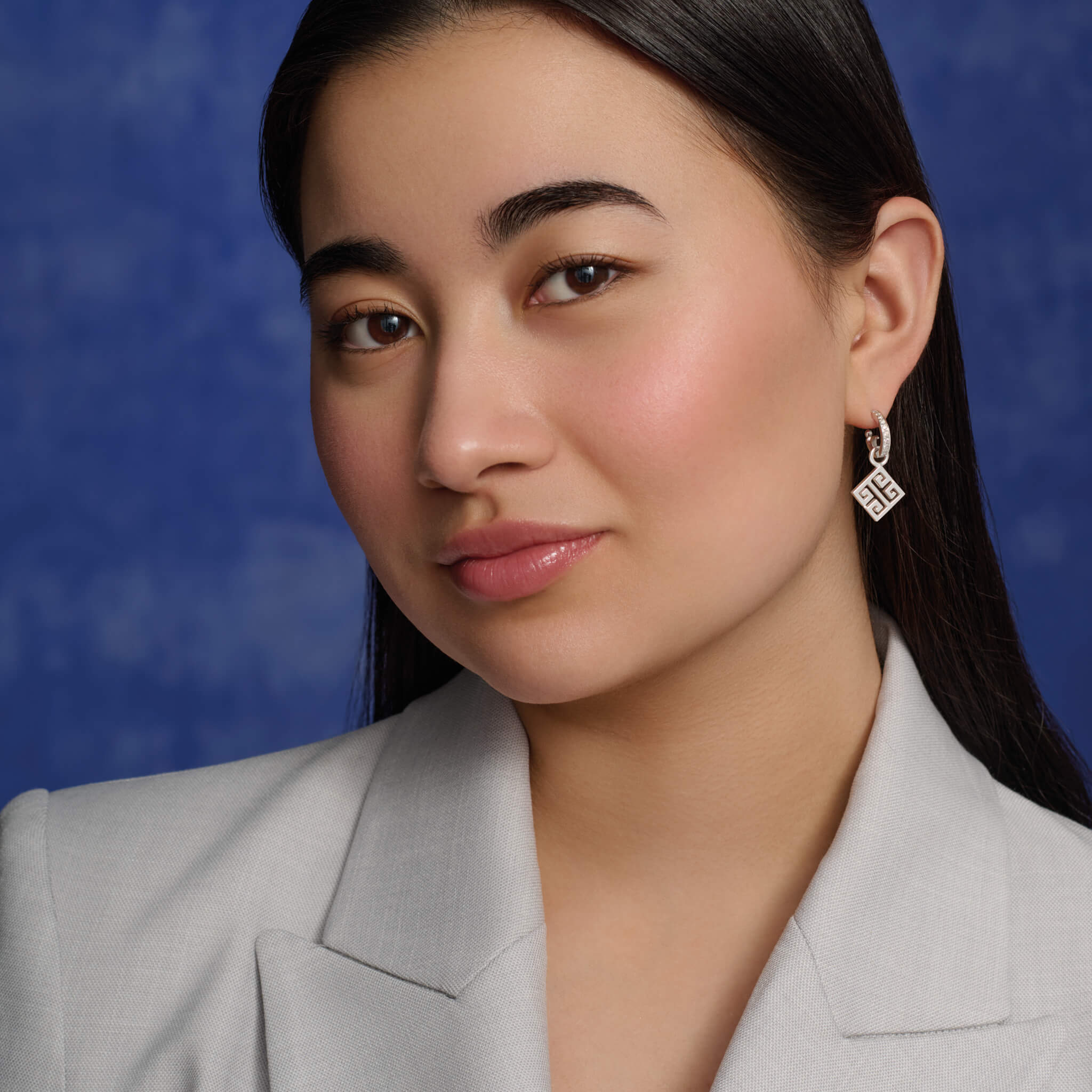 Model wears handcrafted Meandros earring drops in silver.