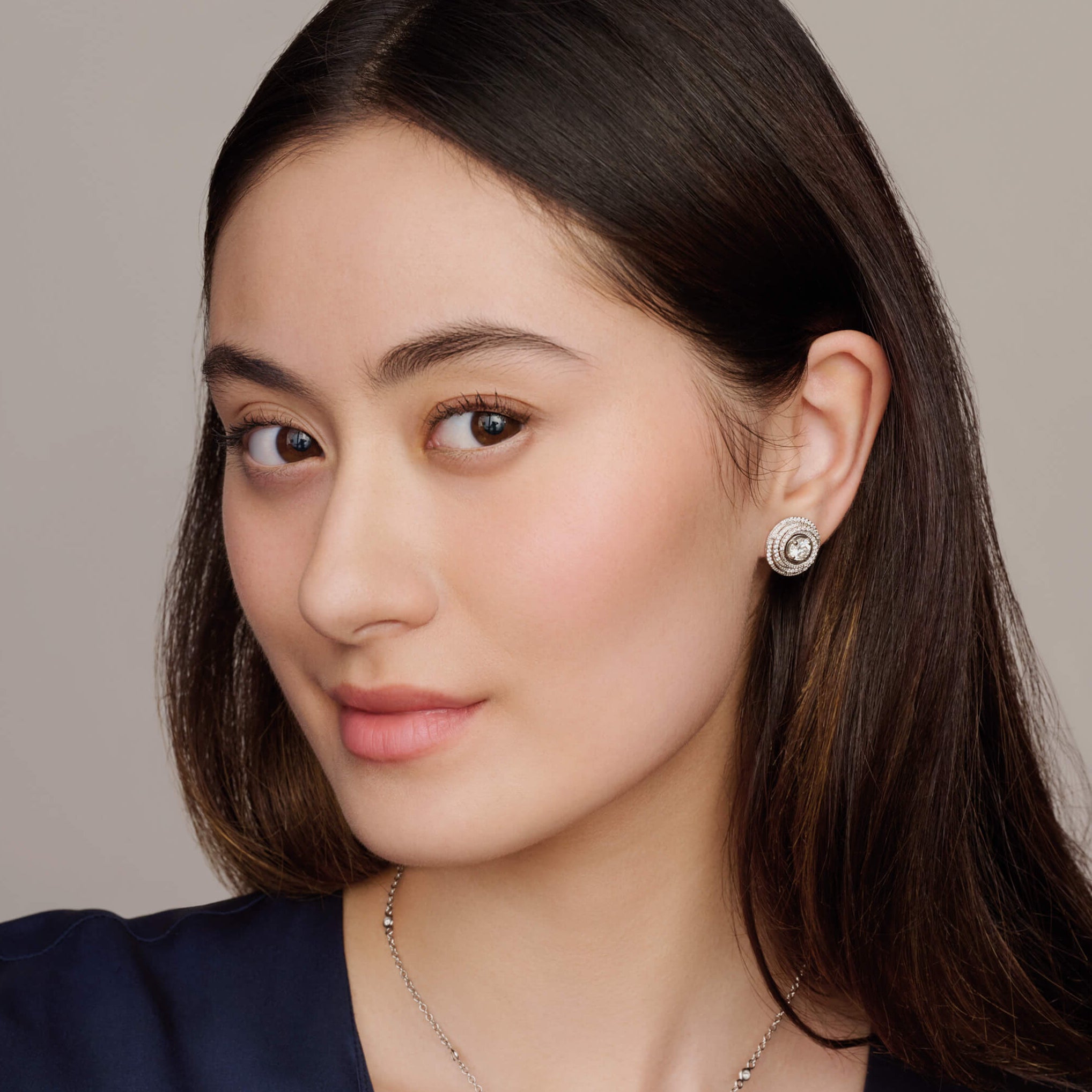 model wearing handcrafted 18ct white gold and diamond earring halos designed to resemble nests of tagliatelle pasta with an interchangeable centre.
