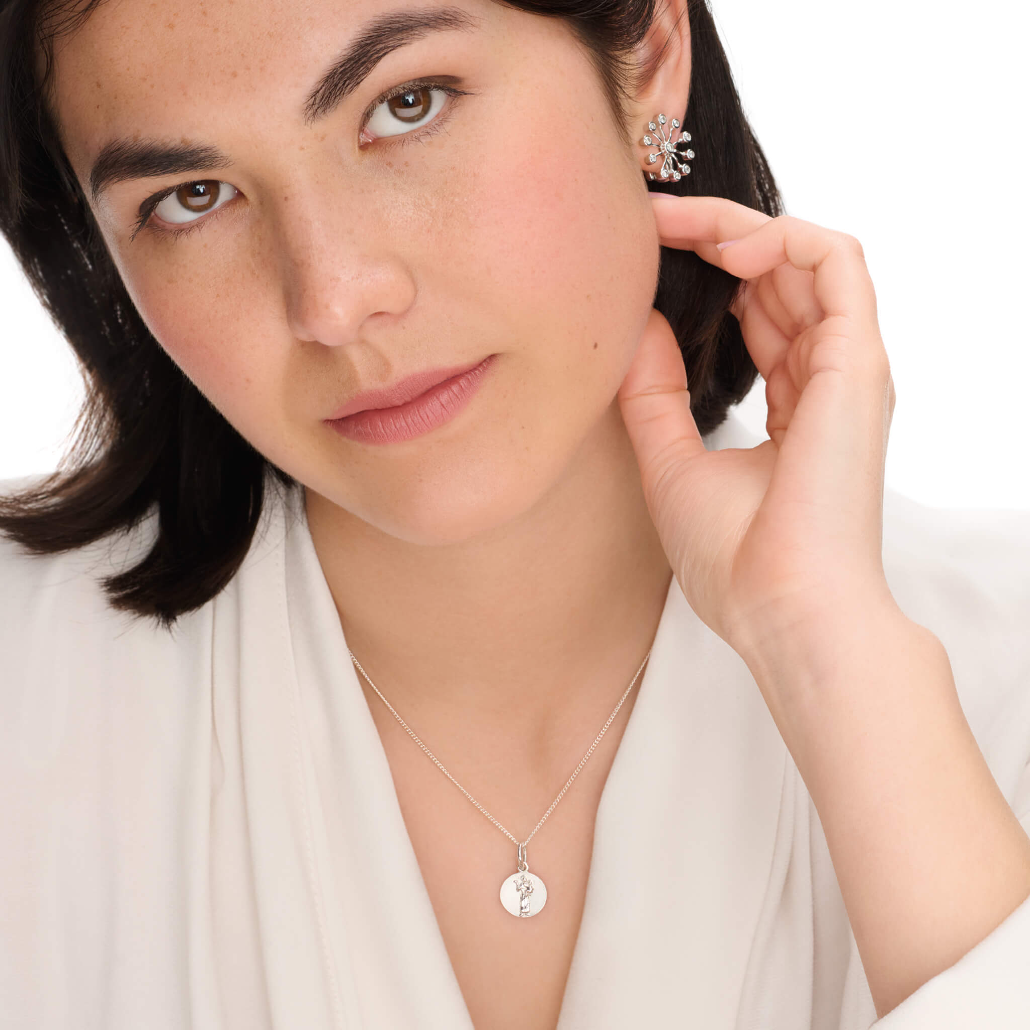 Handcrafted round precious metal necklace pendant featuring an engraving of Saint Francis, with a loop at the top for chain attachment.