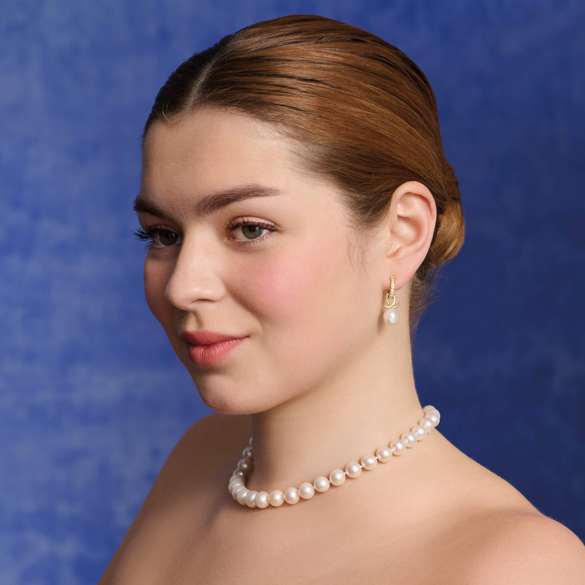Handcrafted 9ct yellow gold earring drops with pearl and an oval loop shape crossing over.