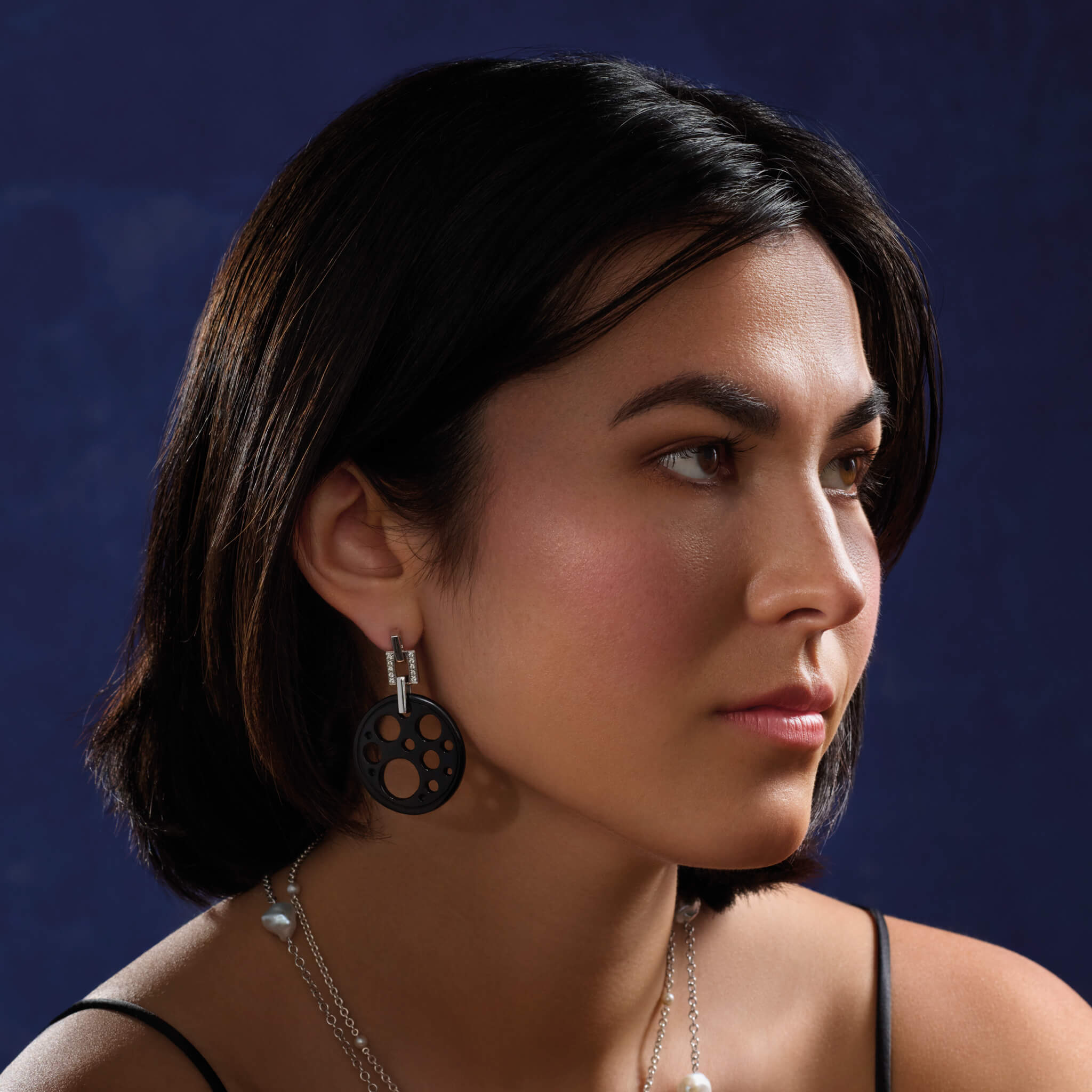 Handcrafted 18ct white gold earrings featuring a circular shape with smaller circular holes of black jade.