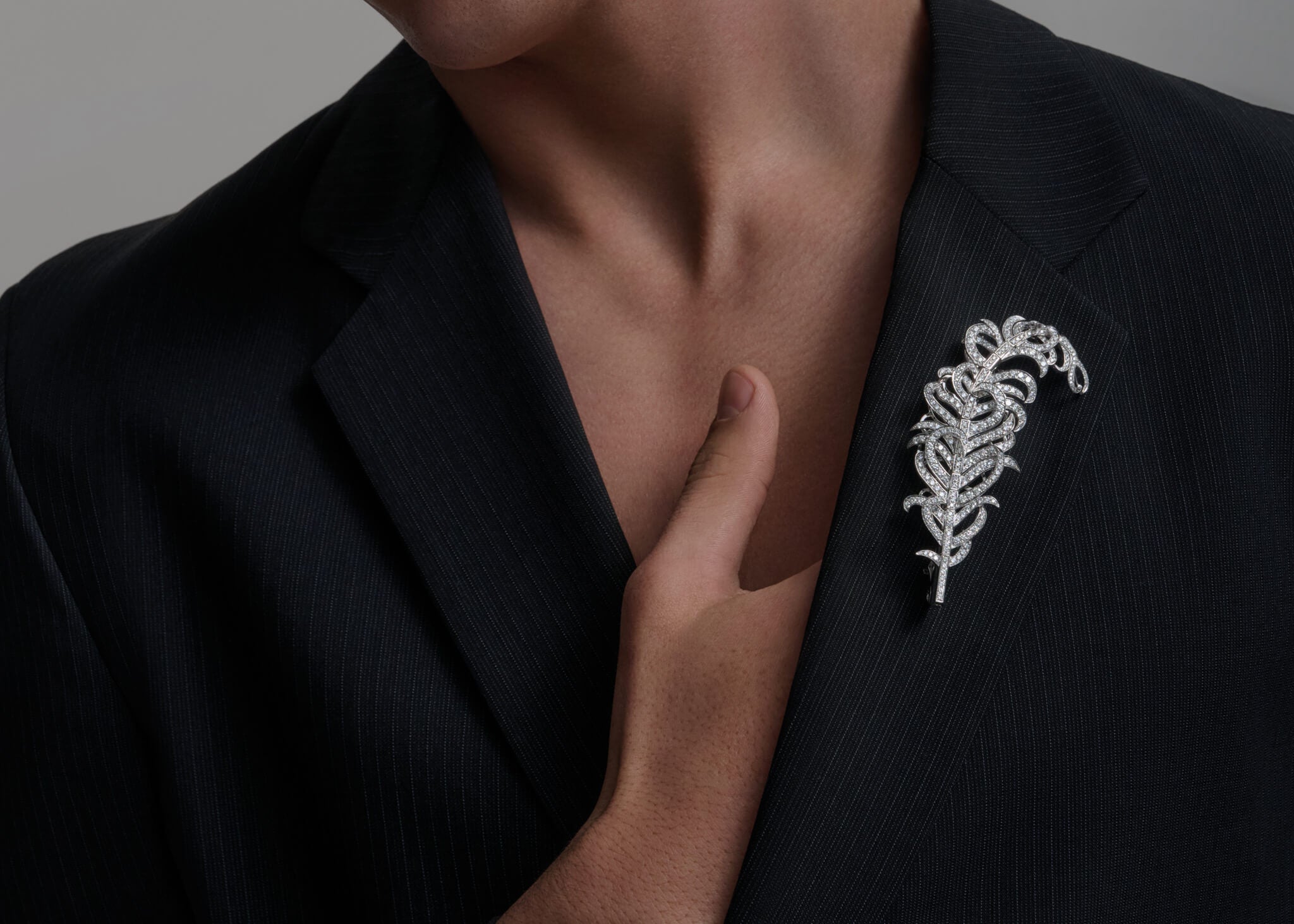 Feather Plume Masterpiece on a dark blazer.
