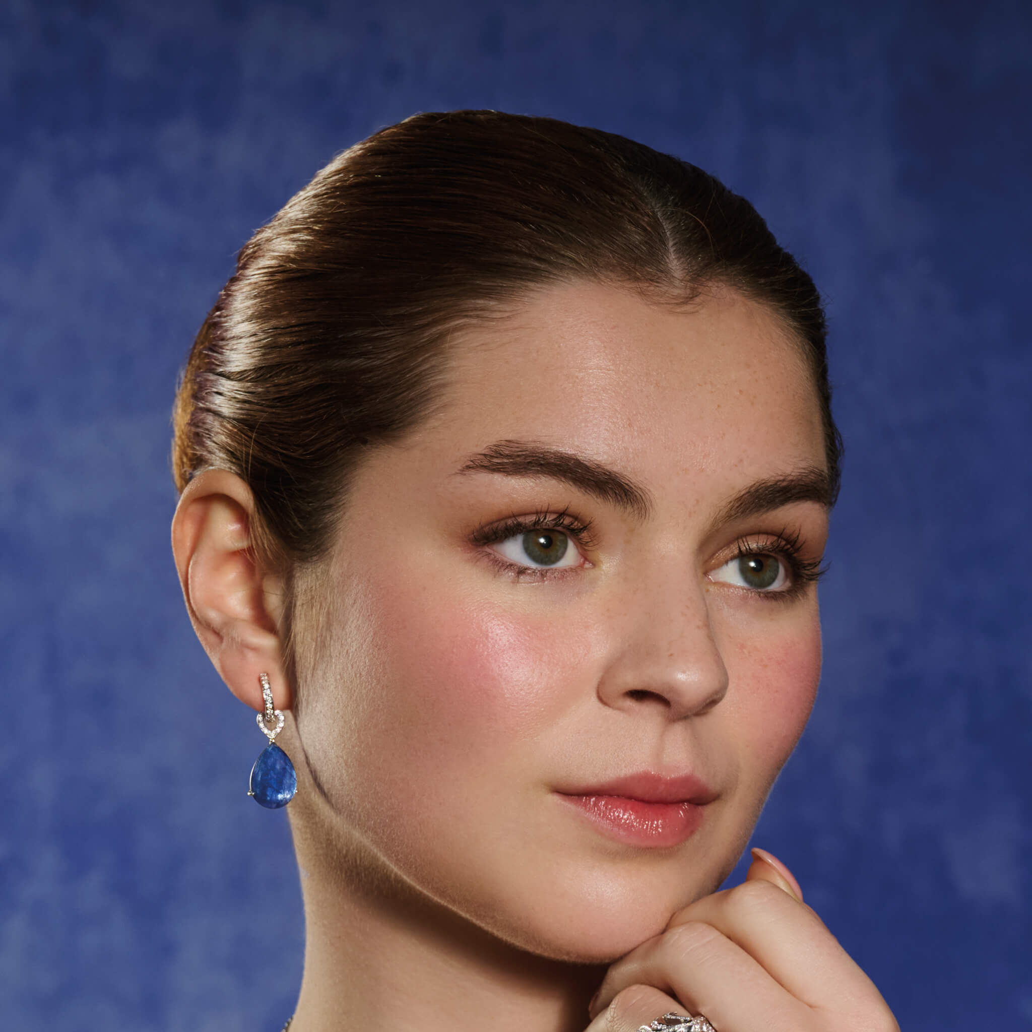 Model wears handcrafted 18ct white gold earring drops featuring drops of blue kyanite with diamonds.