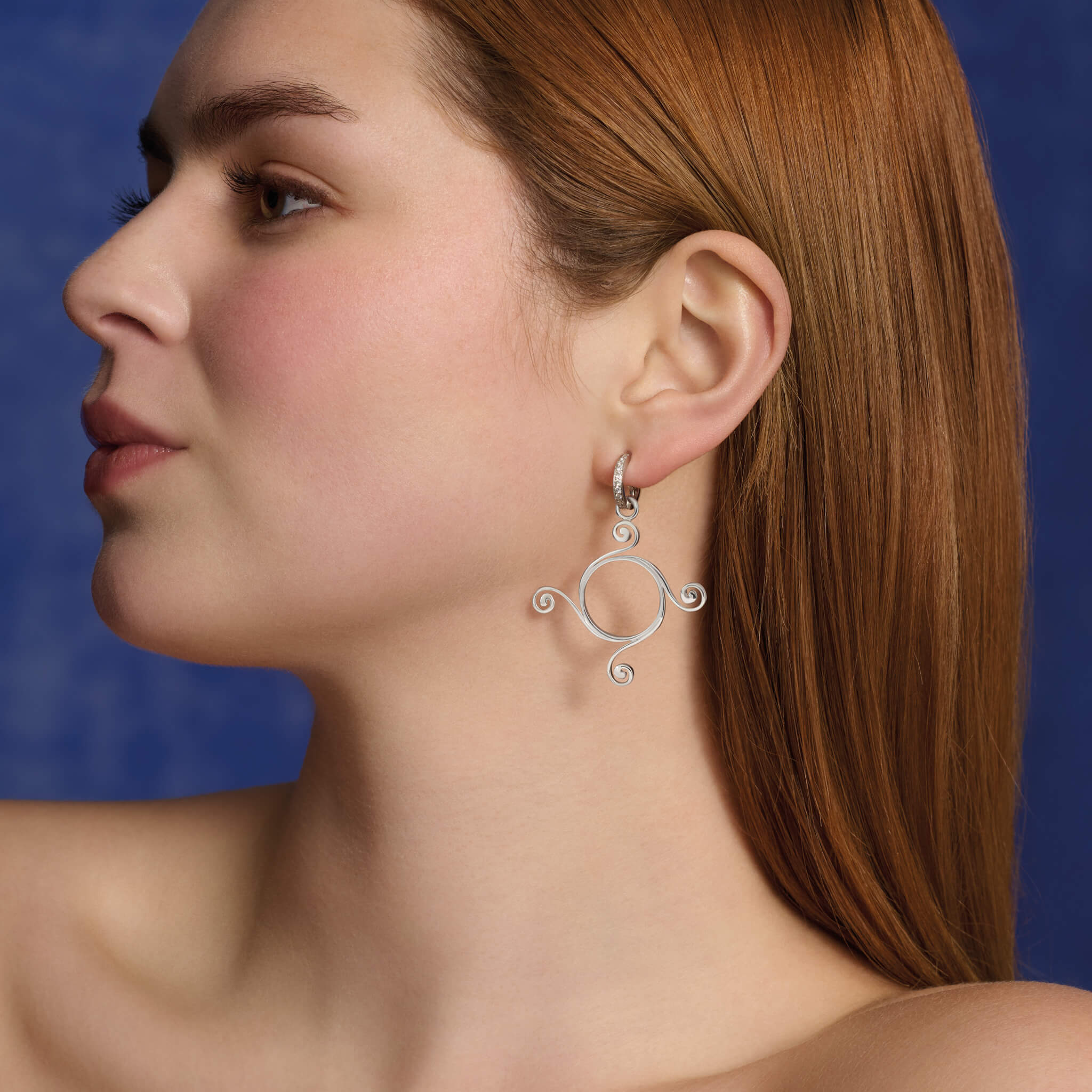 Model wears the handcrafted Athena large earring drops in silver.