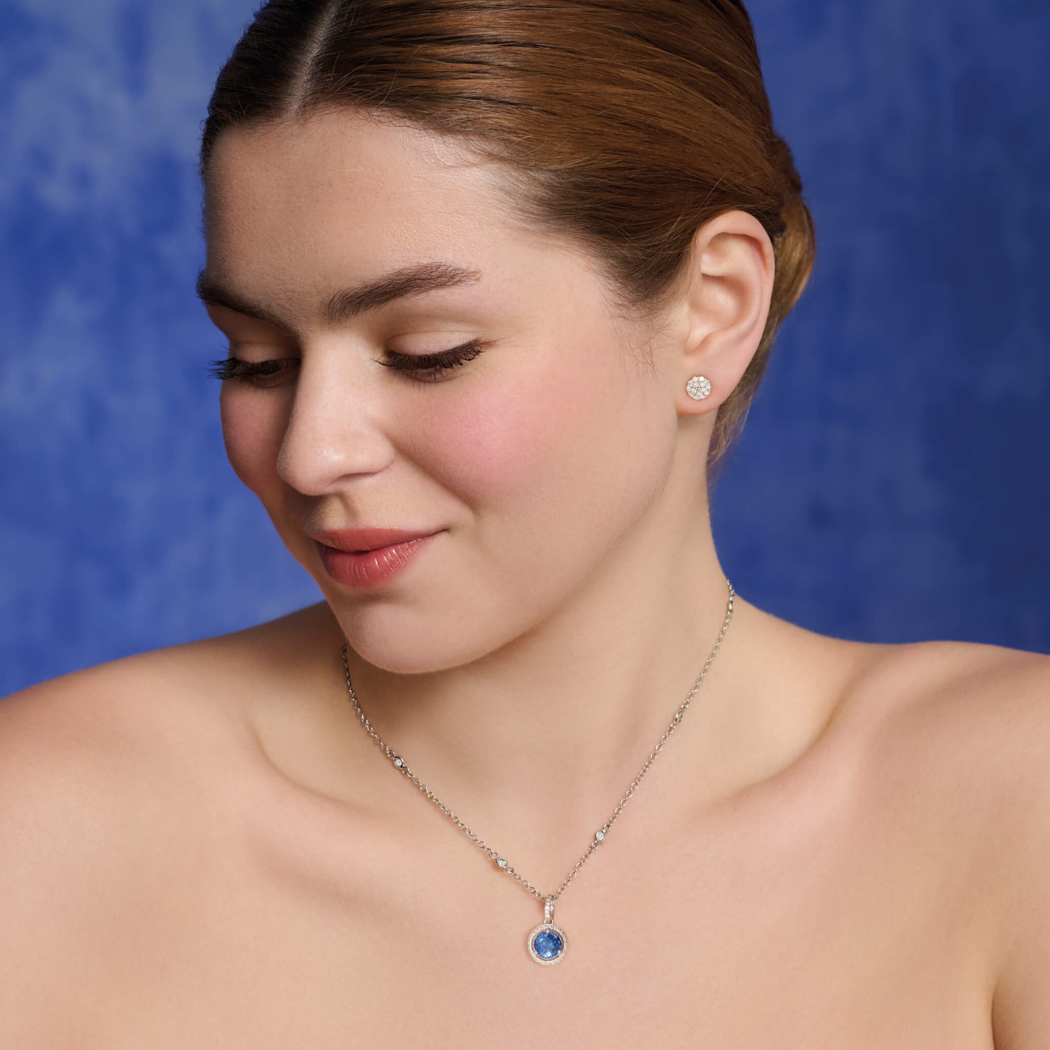 Model wears handcrafted 18ct white gold necklace pendant featuring a circular kyanite with diamonds.
