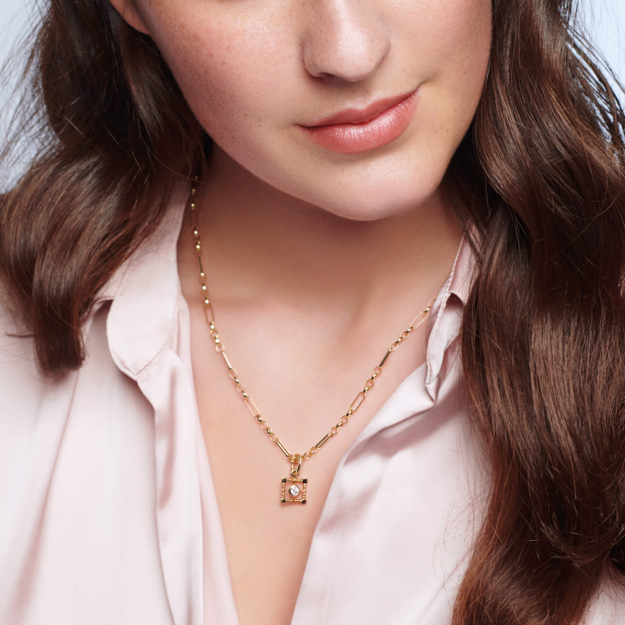 Handcrafted yellow gold necklace pendant  featuring a square-shaped frame with a central diamond, birthstone of April.