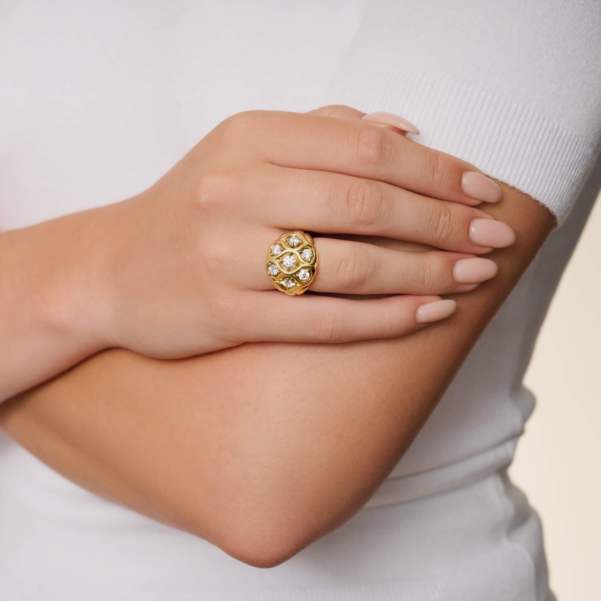 Model wears handcrafted 18ct yellow gold ring with diamond inspired by pleats in Ancient Greek clothing.