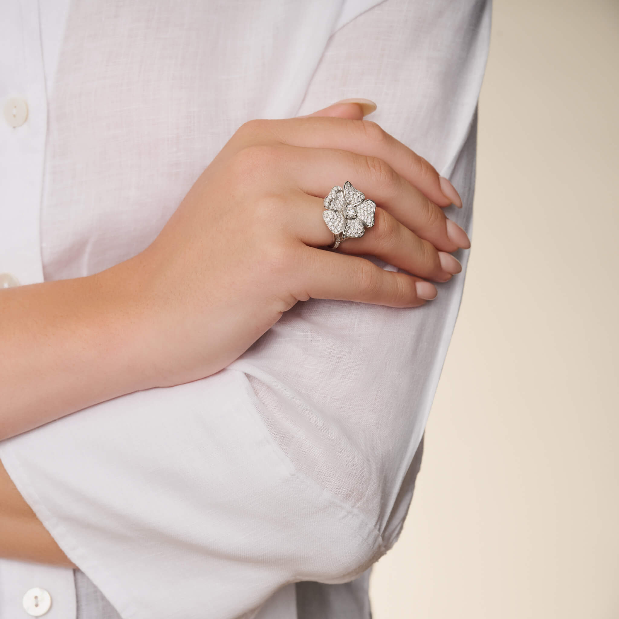 Model wears handcrafted 18ct white gold rose shaped ring with diamonds. 