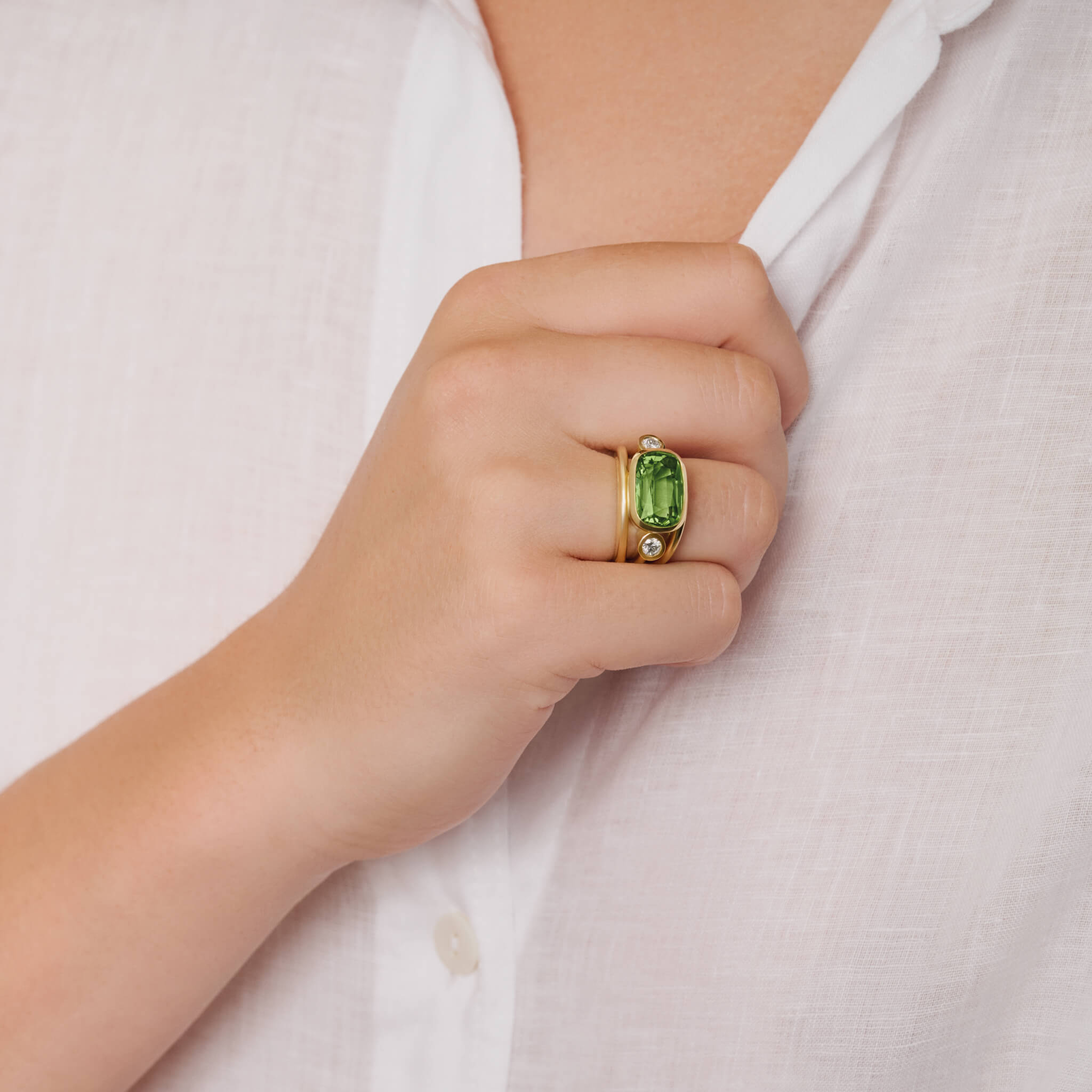 model wears aeneus roman ring in 18ct yellow gold with cushion-cut green tourmaline and diamond by Cassandra Goad, inspired by Aeneas of Troy