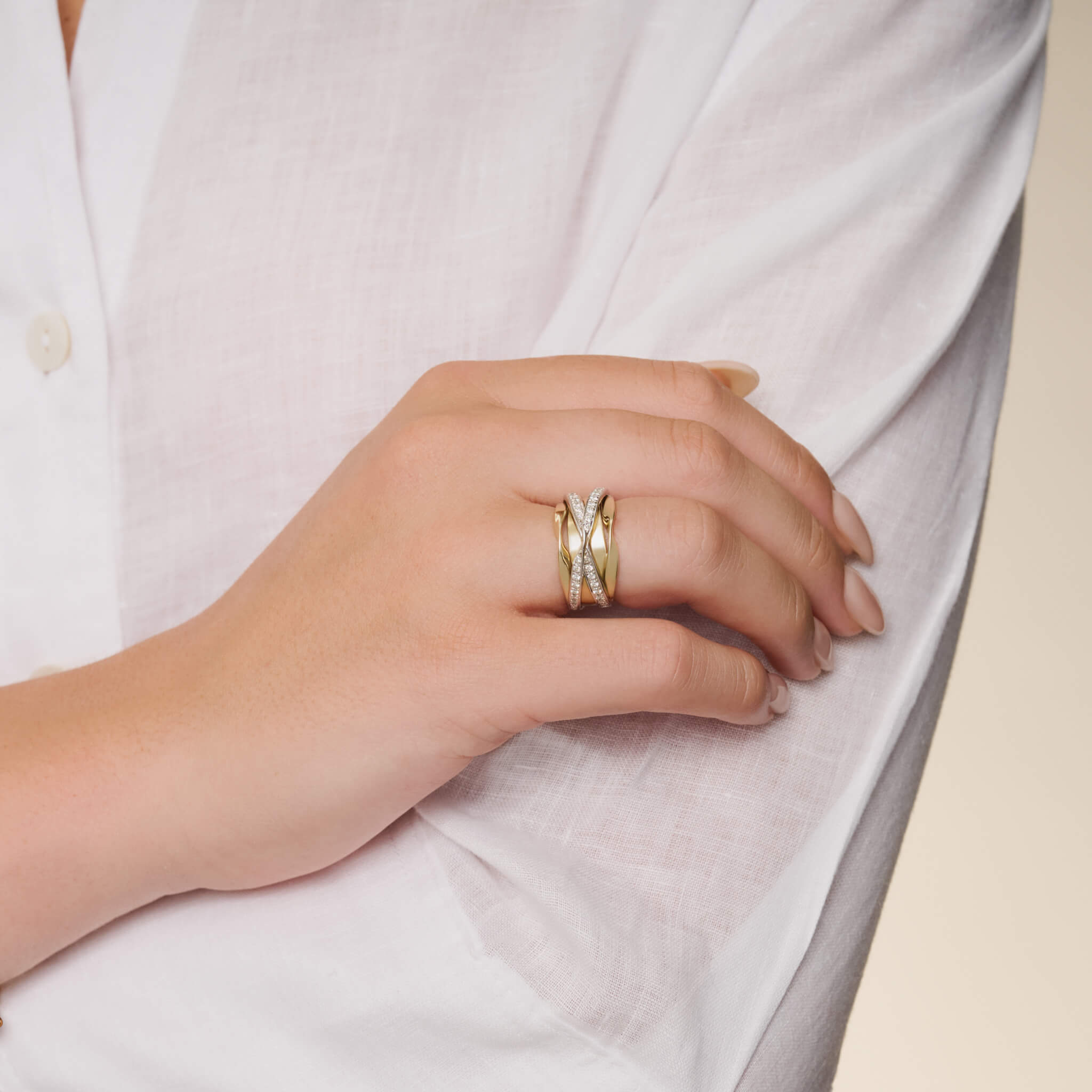 Model wearing a handcrafted 18ct precious mixed metal ring featuring a nest of tagliatelle with diamonds.