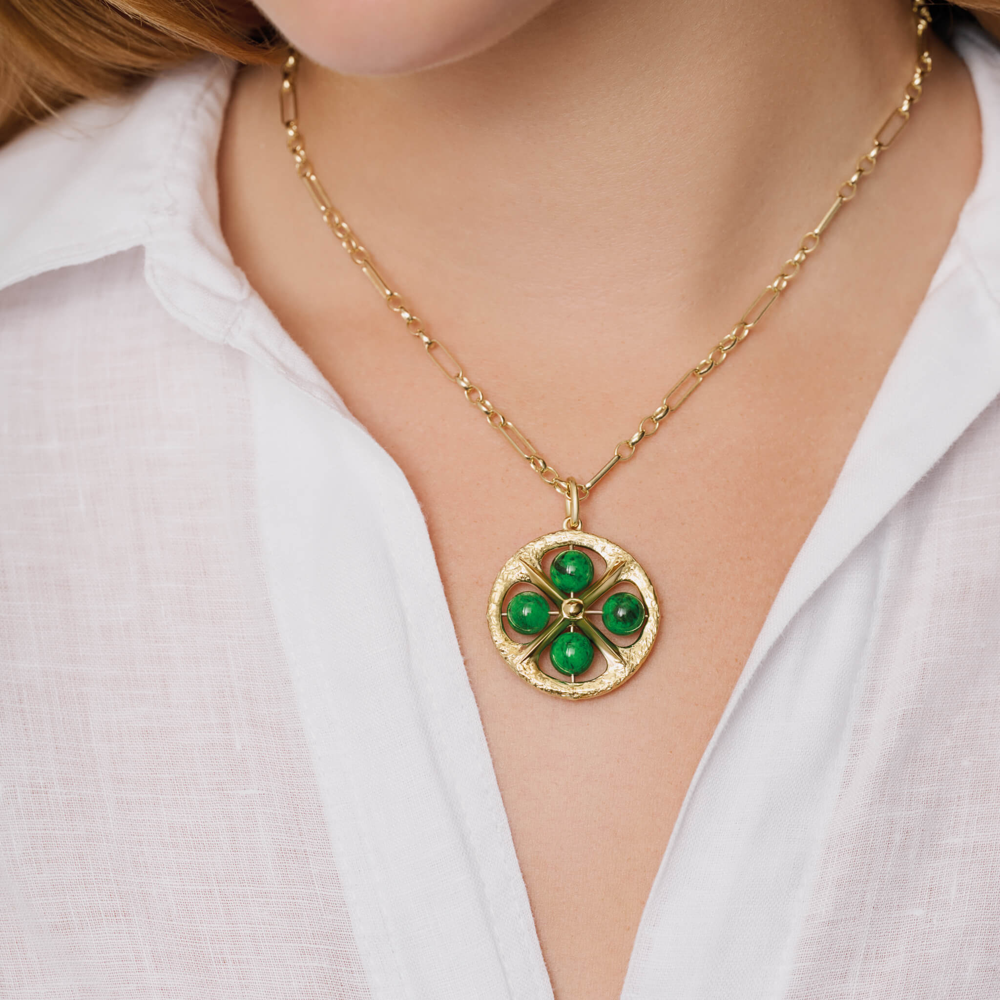 Model wears handcrafted 9ct yellow gold necklace pendant with a circular motif and a cross in the middle and four chloromelanite beads.