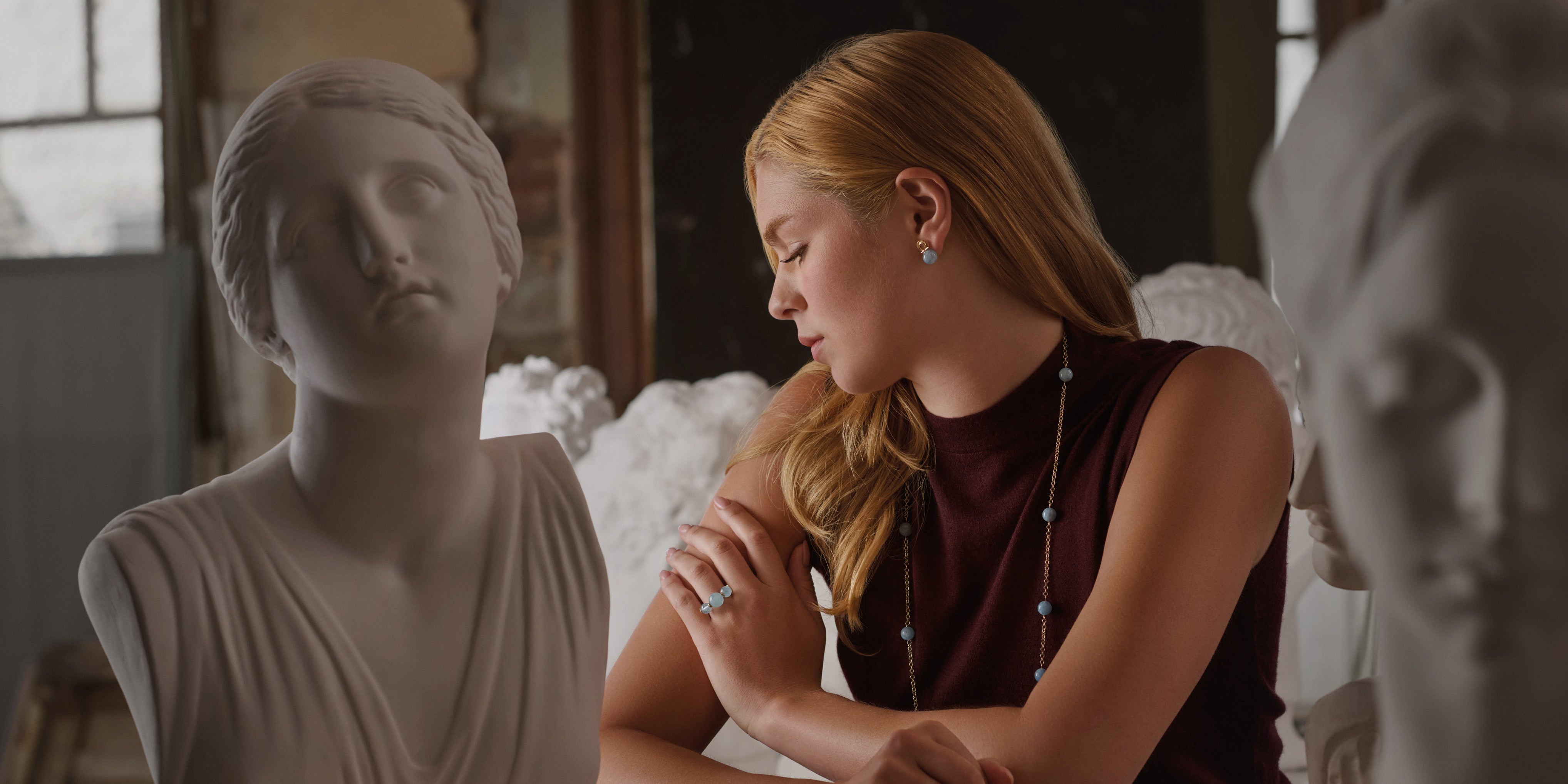 Model wearing handcrafted aquamarine bead jewels, inspired by Greece