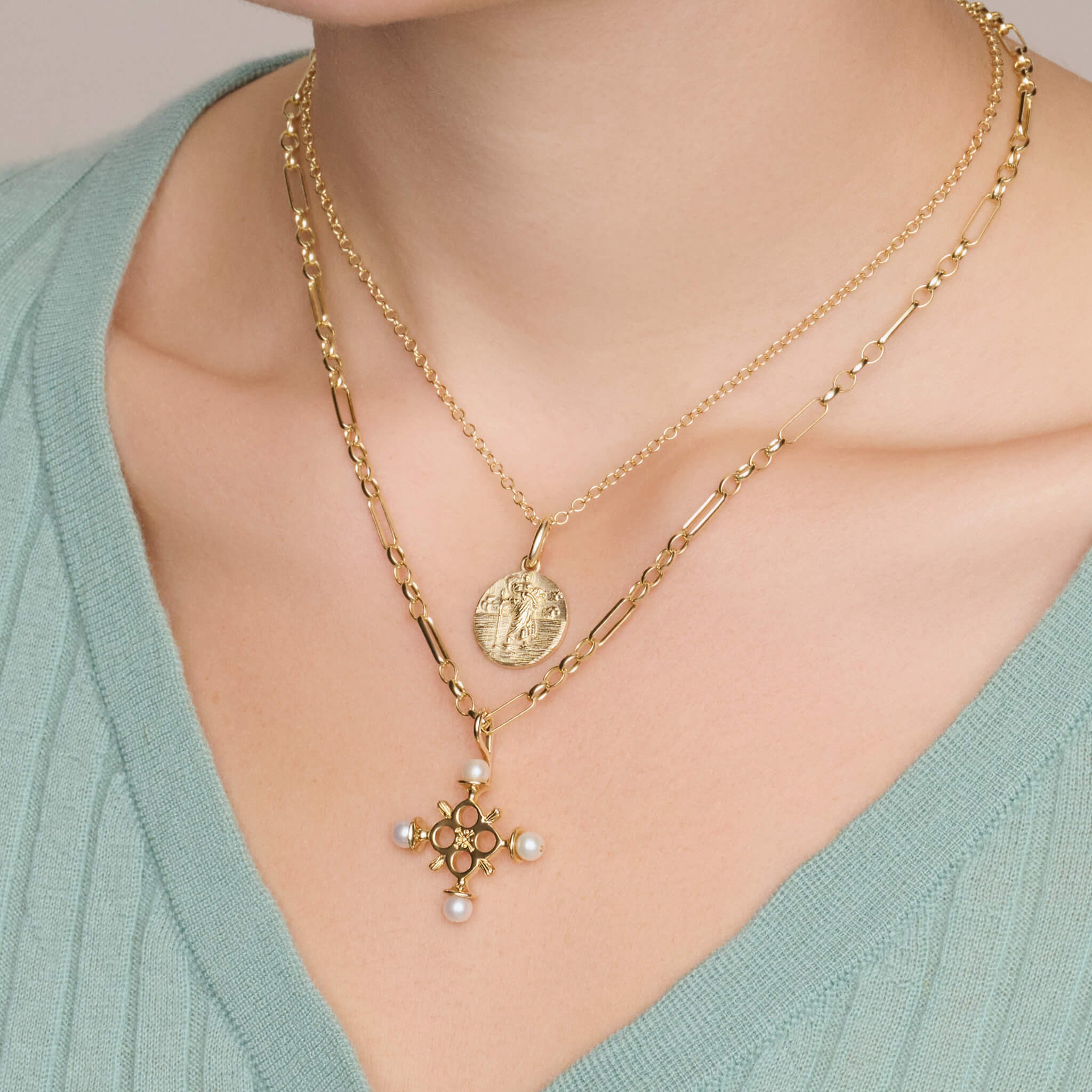 Model wears handcrafted 9ct yellow gold saint pendant of St Christopher with a 9ct yellow gold cross. 