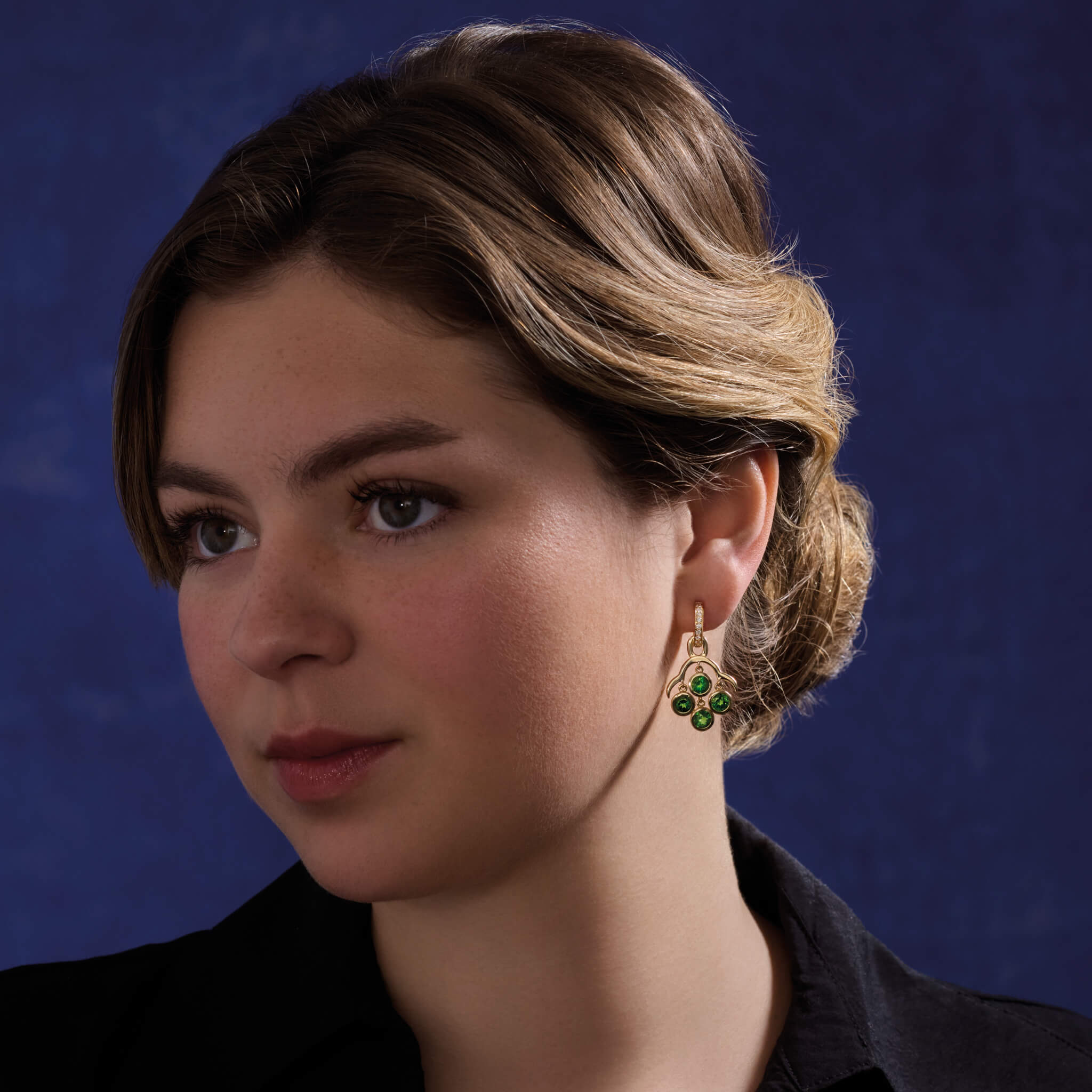 Model wears handcrafted yellow gold earring drops inspired by acai berries featuring four facetted gemstones, on Astrea hoops.