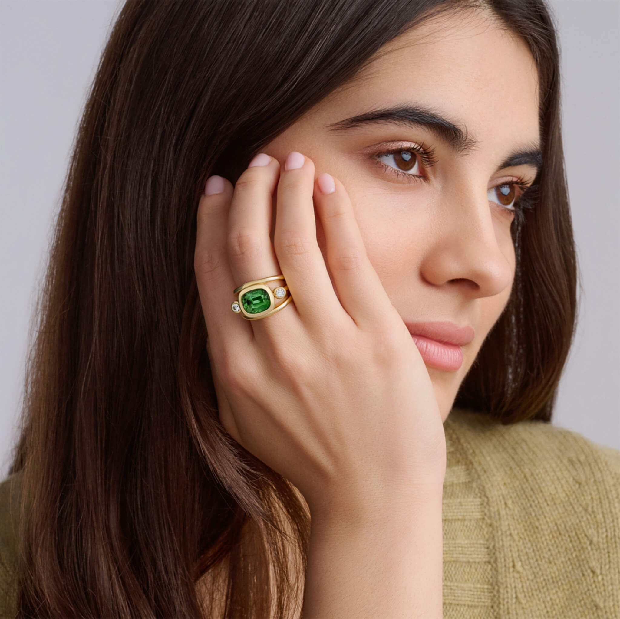 Handcrafted 18ct yellow gold ring with a central green tourmaline, the birthstone of October, flanked by two round diamonds.