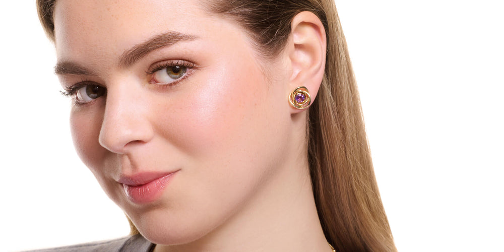 model wearing Cassandra Goad amethyst stud earrings with yellow gold halos. 
