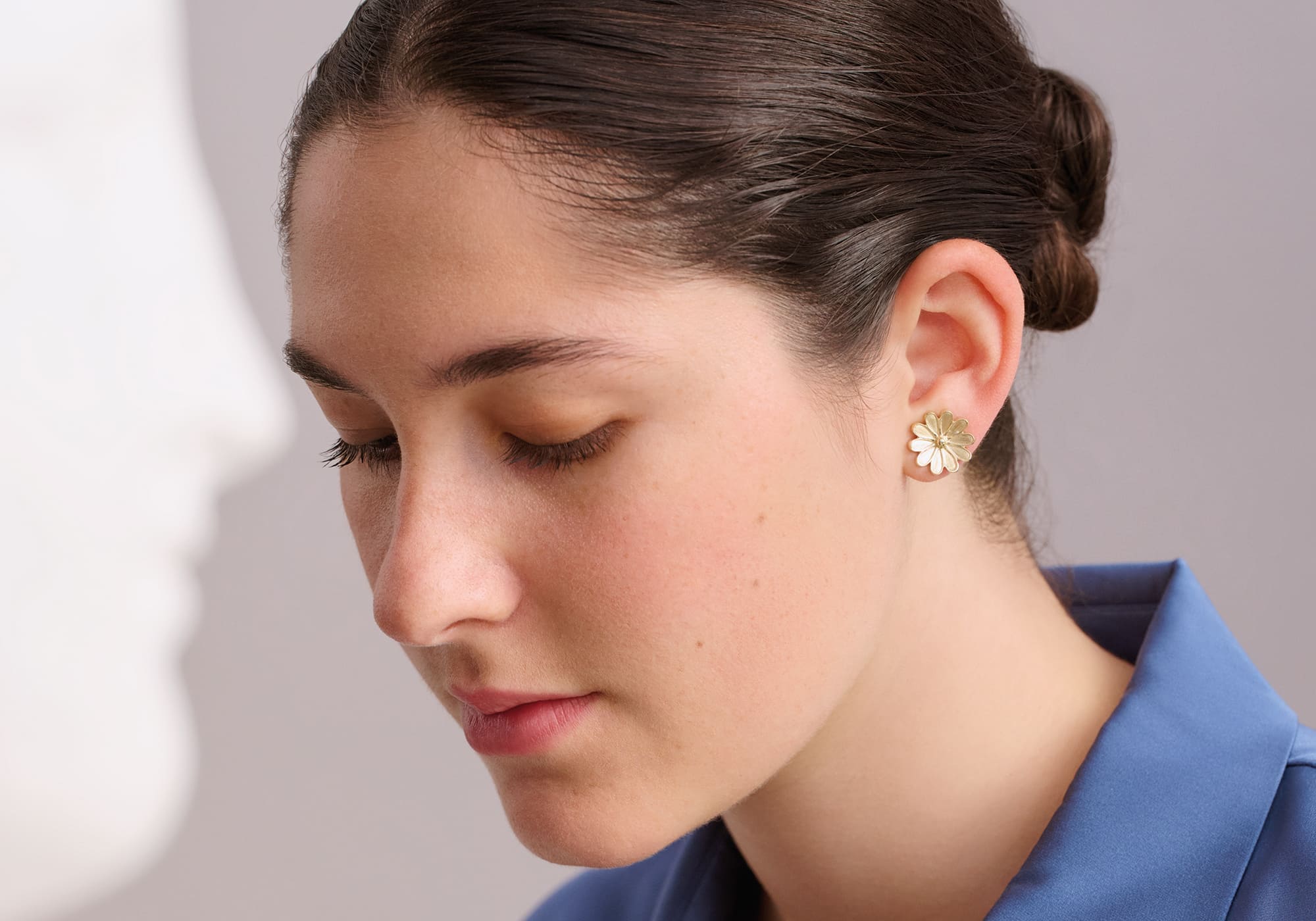 Model wears handcrafted earrings in the shape of an anemone 