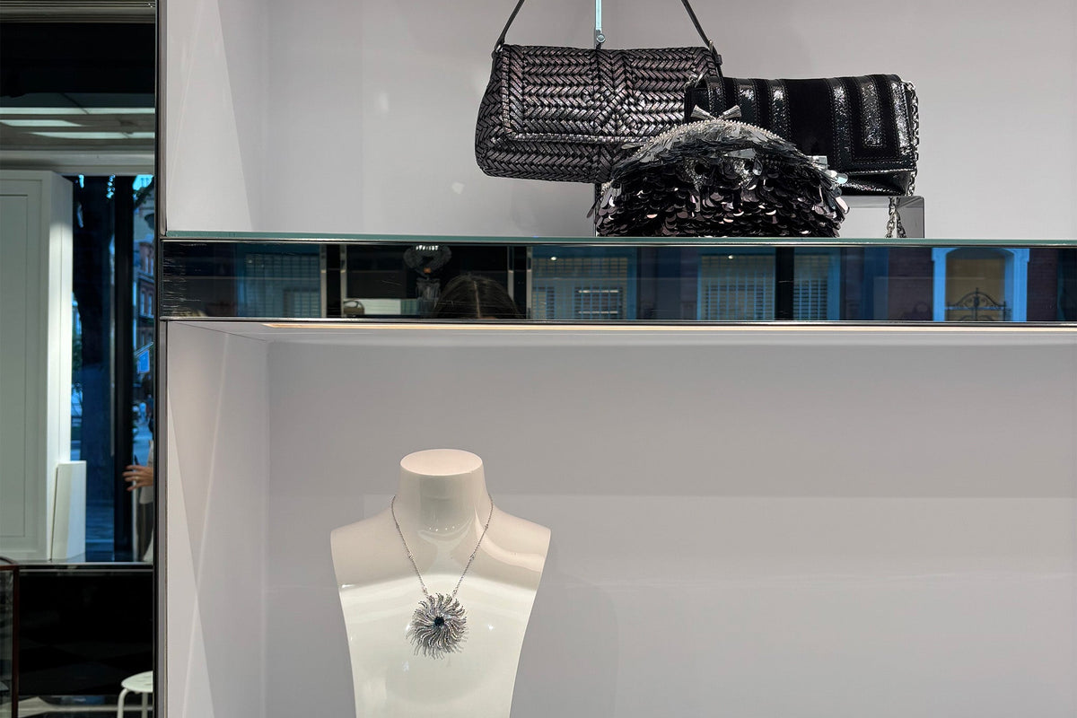 Handcrafted Cassandra Goad jewel in white gold with diamonds and Anya Hindmarch luxury bags