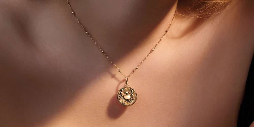 Model wears Cassandra Goad cancer zodiac medallion charm necklace pendant