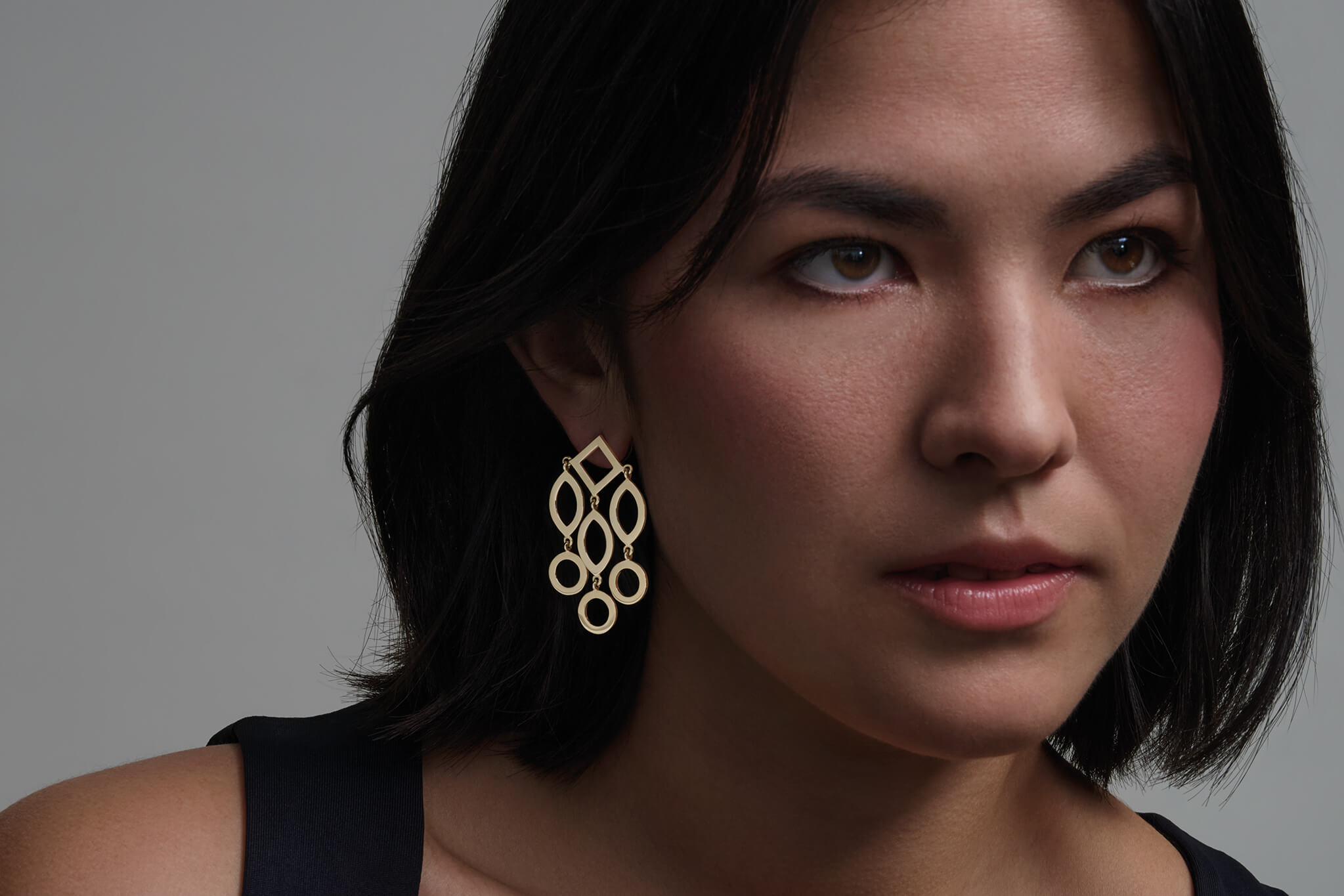 Model wearing handcrafted yellow gold Temple of Heaven earrings inspired by China.