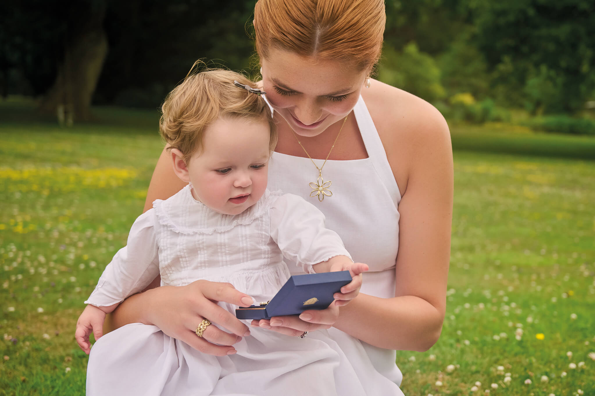 Baby and godparent looking at Cassandra Goad jewellery box.