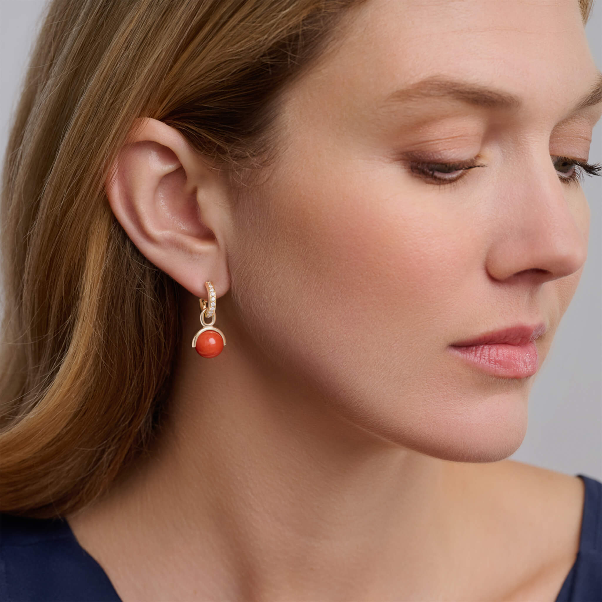Handcrafted yellow gold earring drops featuring coral beads.