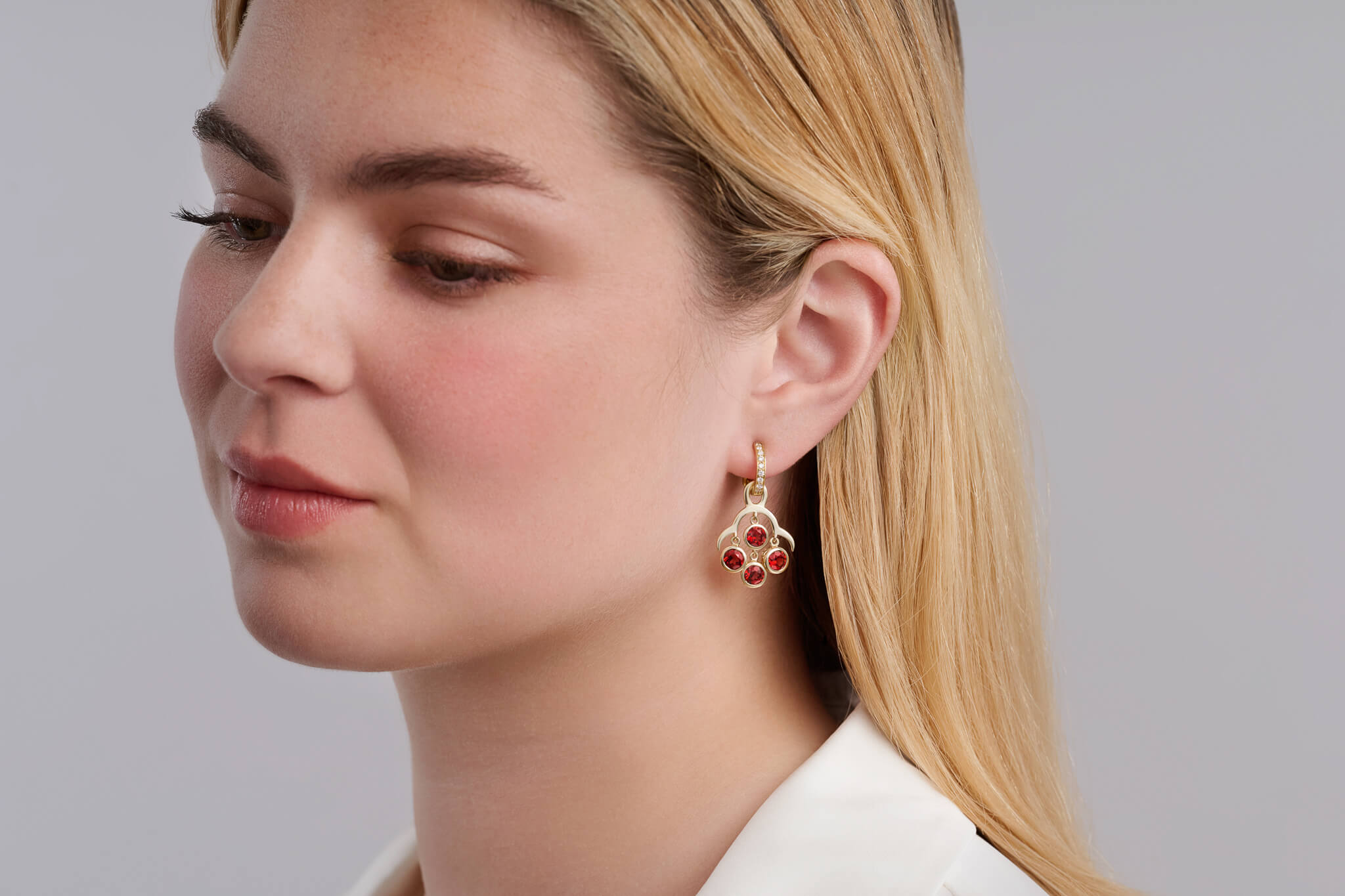 Model wears earrings drop off an Astrea hoop earring showcasing our interchangeable earring drops.