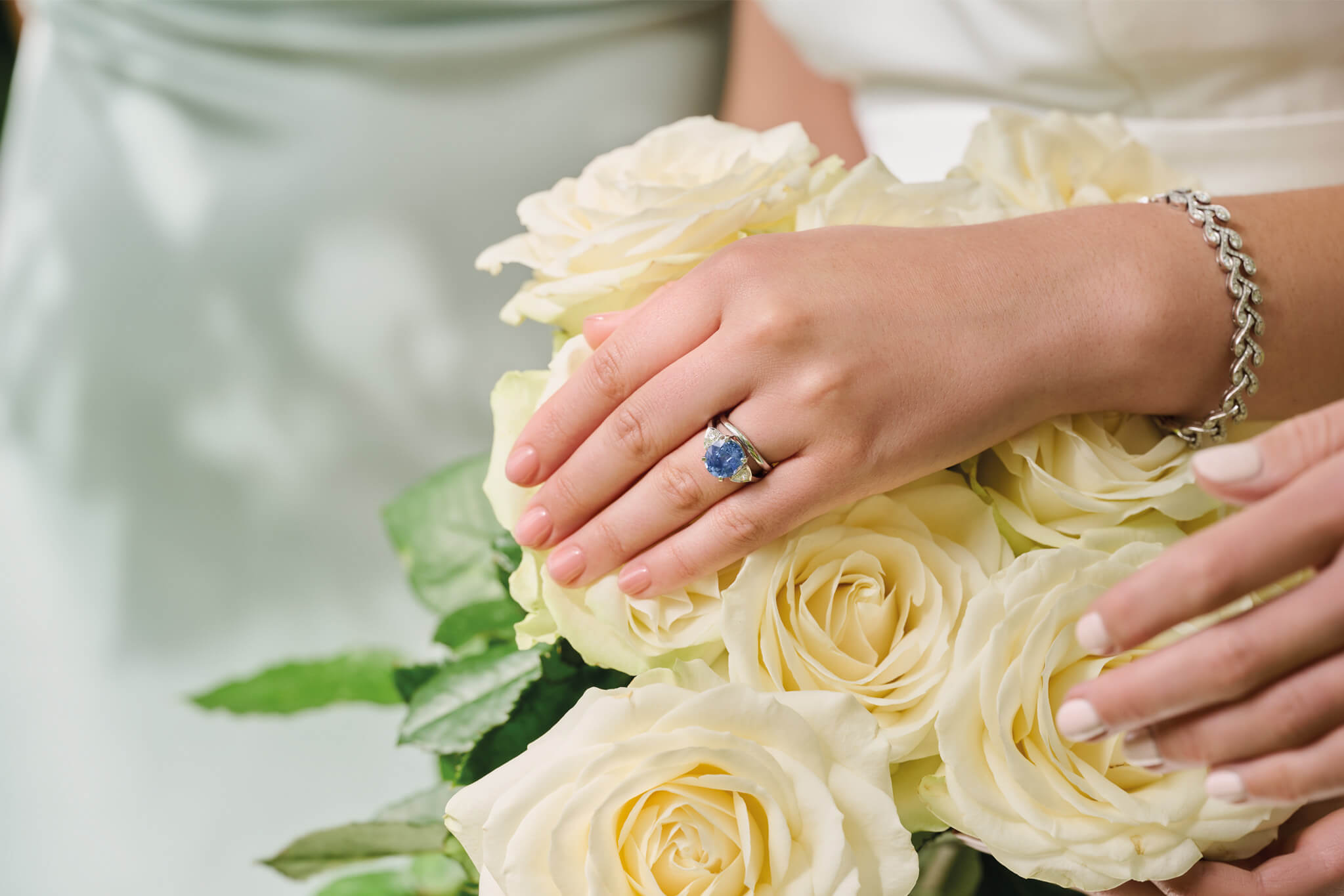 bride wears handcrafted white gold engagement ring, white gold wedding band and bridal jewellery 