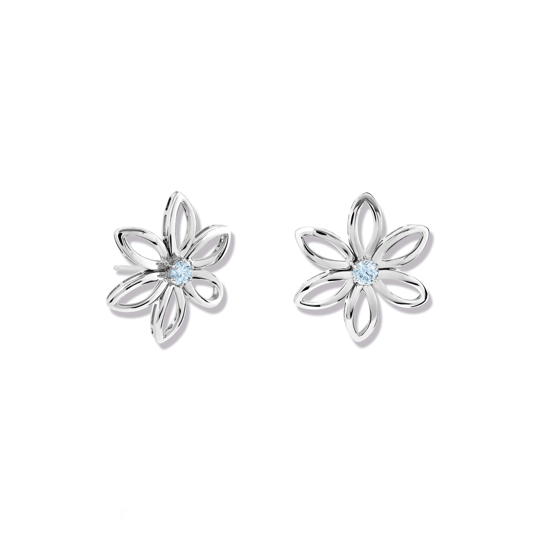 Handcrafted silver flower studs with a central blue topaz, birthstone of November.